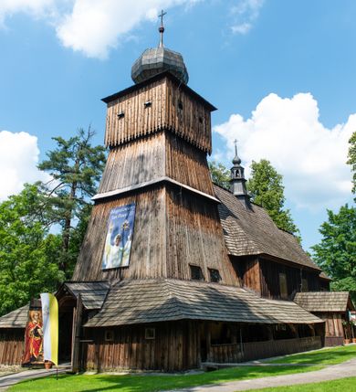 Zdjęcie nr 57: Kościół orientowany, drewniany, na podmurowaniu, o konstrukcji zrębowej, z wieżą o konstrukcji słupowo-ramowej. Składa się z prostokątnej nawy, do której od wschodu przylega węższe prezbiterium zamknięte trójbocznie. Do niego od północy dobudowano prostokątną zakrystię. Do nawy od zachodu przylega wieża na rzucie kwadratu, o ścianach pochyłych, rozdzielona na kondygnacje daszkiem; zwieńczona nadwieszoną izbicą szalowaną pionowymi deskami wyciętymi dołem w ozdobną koronkę; w ścianach izbicy po dwa małe okienka. 
Kościół jednonawowy, z węższym prezbiterium oddzielonym ścianą tęczową. Otwór tęczowy podwójny, górny mniejszy, w strefie sklepień, dolny większy, wycięty w zrębie. Na podniebiu dolnego łuku napis „TEN KOŚCIÓŁ ZAŁOŻONY RP 1789 BENEDYKOWANY RP 1792 MALOWANY RP 1930”. Ściany gładkie, pokryte dekoracją malarską imitującą detale architektoniczne: kolumny, belkowanie, obramienia okien, plafony wypełnione rzeźbiarską dekoracją; między nimi postacie świętych. W nawie od zachodu chór muzyczny wsparty na dwóch, profilowanych słupach, z parapetem wybrzuszonym pośrodku. Nawa i prezbiterium nakryte pozornym sklepieniem kolebkowym z płaskimi odcinkami stropowymi po bokach. 
W nawie głównej cztery okna, w prezbiterium dwa, wszystkie w kształcie stojącego prostokąta; w dolnej kondygnacji wieży dwa okna w kształcie leżącego prostokąta. Wejście główne od zachodu, kolejne od południa, oba portale zamknięte od góry łukiem „w ośli grzbiet”; portal z prezbiterium do zakrystii.  
Kościół obiegają soboty, czyli rodzaj podcieni, zamkniętych wokół wieży, otwartych na pozostałej długości; z kruchtami od zachodu i od południa; cztery kwadratowe okienka w sobotach od zachodu. 
Ściany na zewnątrz kościoła pobite deskami. Nad nawą główną dach dwuspadowy, nad prezbiterium wielopołaciowy, przedłużony od północy na zakrystię. Na dachu nawy zwężająca się ku górze wieżyczka na sygnaturkę, która przechodzi w latarnię o cebulastym zakończeniu. Wieżę zachodnią wieńczy hełm złożony z niskiego dachu namiotowego i nasadzonej na niego bani z kulą i krzyżem. Soboty nakryto dachem pulpitowym, wygiętym przy ścianie wschodniej zakrystii łukowo ku górze po to, aby lepiej ją doświetlić. Dachy kryte gontami, hełmy wież blachą. 
