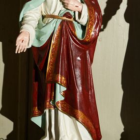 Zdjęcie nr 1: Rzeźba pełnoplastyczna na prostopadłościennej podstawie z otworami na drążki, przedstawiająca Chrystusa stojącego frontalnie w kontrapoście. Prawą ręką dotyka unoszącego się przed jego piersią gorejącego serca ujętego koroną cierniową i zwieńczonego krzyżem. Lewą rękę wyciąga przed siebie prezentując ranę. Głowa lekko przechylona, wzrok skierowany przed siebie, oczy jasne, nos prosty, usta niewielkie, czerwone. Na twarzy krótki brązowy zarost, falowane włosy opadają na ramiona i plecy. Chrystus jest ubrany w białą suknię z długimi rękawami, przewiązaną w pasie złotym sznurem, za który ma zatknięty czerwony płaszcz z jasnozielonym podszyciem i pasem złotego ornamentu przy brzegu okrywający ramiona i nogi. Polichromia w partiach ciała naturalistyczna. Rzeźba stoi na bordowym cokole umocowanym na ciemnobrązowej podstawie. 