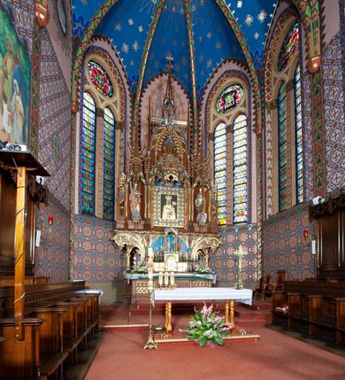 Zdjęcie nr 5: Kościół jest położony na północny-zachód od centrum miejscowości, na placu otoczonym ceglanym murem na podmurówce z murowanymi słupkami, nakrytym blaszanym daszkiem. Główne wejście na plac kościelny prowadzi przez pseudobastionową bramę, flankowaną dwiema pseudowieżyczkami oraz dwiema furtkami. Kościół jest budowlą założoną na planie krzyża łacińskiego, murowaną z cegły, orientowaną, jednonawową z transeptem, prezbiterium zakończonym trójbocznie i wieżą. Od północnej strony kościoła prostokątna zakrystia, od południa w narożniku korpusu i prezbiterium niewielkie kruchty. 

Wnętrze artykułowe ostrołukowymi arkadami wspartymi na filarach. Korpus sześcioprzęsłowy, nakryty sklepieniem krzyżowo-żebrowym; prezbiterium dwuprzęsłowe, węższe od korpusu ze sklepieniem gwiaździstym. Chór muzyczny wsparty na trzech arkadach. W kościele duże okna pseudomaswerkowe w kształcie stojących prostokątów, zamkniętych ostrołukowo, wypełnione witrażami.

Na zewnątrz elewacje ceglane z kamiennym cokołem, zamknięte kamiennym gzymsem podokapowym. Od fasady po lewej stronie dostawiona masywna wieża na planie kwadratu, czwórkondygnacyjna. W dolnych kondygnacjach niewielkie okienka, trzecia kondygnacja najwyższa, a w niej wysokie prześwity okienne z biforiami, wyżej zegary na każdej ścianie wieży. Ostatnia kondygnacja najwyższa z otworami okiennymi w kształcie leżących prostokątów, zamkniętych odcinkowo, wypełnionych podwójnymi biforiami. Wieża nakryta ostrosłupowym hełmem z analogicznymi czterema mniejszymi hełmami w narożach. Po prawej stronie fasady kruchta wejściowa do kościoła założona na planie prostokąta z portalem od zachodu, nakryta daszkiem jednospadowym, od południa zwieńczonym kamiennym szczytem schodkowym. Portal wysunięty przed lico kruchty, w polu ostrołukowa arkada z tympanonem przedstawiającym Chrystusa spotykającego Marię Magdalenę. Portal zamknięty trójkątnym szczytem, którego pole wypełnione jest rzeźbioną dekoracją z liści i owoców winnego grona oraz krzyża łacińskiego pośrodku. Za kruchtą ściana zachodnia kościoła zamknięta trójkątnym szczytem schodkowym, wypełnionym blendami. Analogiczne szczyty na zakończeniu ramion transeptu oraz na zakończeniu korpusu nawy kościoła od strony wschodniej. Nad skrzyżowaniem ramion transeptu umieszczona jest wieżyczka na sygnaturkę. Do świątyni prowadzą też dwa mniejsze wejścia od strony południowej przez kruchty oraz trzecie przez zakrystię. Korpus nakryty wysokim, dwuspadowym dachem. Ramiona transeptu nakryte osobnymi dachami dwuspadowymi o kalenicy niższej niż dach korpusu. Na zewnątrz kościół oszkarpowany. 