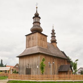 Zdjęcie nr 1: Kościół zlokalizowany na zachodnim krańcu wsi. Plac kościelny otoczony drewnianym płotem. W północno-wschodnim narożu drewniana dzwonnica.  
Kościół orientowany, drewniany, konstrukcji zrębowej, z wieżą na słup od zachodu, wejście główne od zachodu; wejścia boczne od południa przez kruchtę i od północy przez zakrystię. Prezbiterium zamknięte wielobocznie, nawa na rzucie prostokąta. Przy prezbiterium i nawie od północy zakrystia z przedsionkiem, przy nawie od południa kruchta. Wewnątrz stropy, podkreślone profilowanym gzymsem. Łuk tęczowy o wykroju prostokątnym ze ściętymi narożami, flankowany filarkami z belkowaniem; na nim późnobarokowy krucyfiks podtrzymywany przez aniołka, ponad belkowaniem aniołki dzierżące narzędzia Męki Pańskiej. Drugi łuk tęczowy usytuowany na granicy przedłużenia naw o podobnym wykroju. Chór muzyczny wsparty na dwóch żłobkowanych słupach o falistym przebiegu. Ściany nawy przeprute: od północy oknem o kształcie prostokąta, od południa trzema analogicznymi oknami i zwieńczone profilowanym gzymsem. Obramienia okienne fazowane, z nadokiennikami o wykroju w ośli grzbiet. Drzwi prowadzące do kruchty w kształcie prostokąta. Prezbiterium wzniesione o jeden stopień powyżej poziomu nawy, od południa przeprute dwoma prostokątnymi oknami. Od północy drzwi do zakrystii o kształcie stojącego prostokąta, od strony zakrystii profilowane. Zakrystia na planie prostokąta, przylegająca od północy do prezbiterium kościoła. Nawa i kruchta kryte dachem dwuspadowym, prezbiterium trójpołaciowym, opadającym ku wschodowi, zakrystia dachem pulpitowym. Przy wschodnim krańcu dachu nawy znajduje się wieżyczka na sygnaturkę. Dzwonnica drewniana, dwukondygnacyjna na planie zbliżonym do kwadratu. Nad pierwszą kondygnacją dach okapowy, a nad drugą czterospadowy, zwieńczony kulą z krzyżem. Na fasadzie kruchty wnęka z rzeźbą Matki Boskiej z Dzieciątkiem. 


