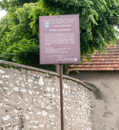 Zdjęcie nr 17: Kościół orientowany, murowany, jednonawowy z prezbiterium zakończonym wielobocznie. Wschodnia część węższa, prostokątna, zachodnia szersza, trójnawowa, halowa. Do prezbiterium od północy przylega zakrystia, do wschodniej części korpusu przybudówka, od zachodu kruchta. Ściany nawy dzielą pilastry. Prezbiterium sklepione krzyżowo, absyda konchowo z lunetami, nawy kolebkowo z lunetami. Od zachodu chór wsparty na dwóch czworobocznych słupach. Jego parapet jest wybrzuszony w części środkowej, ażurowy, zakończony u dołu listwą wycinaną w formie stylizowanych listków. W prezbiterium jedno okno w kształcie stojącego prostokąta zamknięte łukiem pełnym i jedno ślepe, zamknięte łukiem ostrym. Od strony  północnej do zakrystii dwa okna zamknięte łukiem odcinkowym i cztery prostokątne, dwa okna zamknięte łukiem pełnym do zachodniej części nawy; od strony południowej pięć okien zamkniętych łukiem pełnym. Główne wejście od zachodu, drugie od południa, kolejne do  zakrystii, portal z prezbiterium do zakrystii, z czarnego marmuru. Fasada dwuwieżowa, z kruchtą, do której prowadzi ciąg schodów. Kruchta prostopadłościenna, z dachem dwuspadowym, z portalem w kształcie prostokąta zamkniętego łukiem pełnym na osi między oknami powtarzającymi ten kształt. Nad kondygnacją trójkątny przyczółek z krzyżem łacińskim. Fasada dwukondygnacyjna, z wieżami wtopionymi w lico. Pierwsza kondygnacja gładka, flankowana szkarpami, zamknięta gzymsem, druga również niemal gładka, z zegarem na środku i małymi oknami w partii wież. Na osi trójkątny przyczółek. Elewacje obiega cokół, wspierają szkarpy – najgęściej ustawione wokół prezbiterium. Dachy naw dwuspadowe, nad prezbiterium dach zakończony wielobocznie, nad zakrystią pulpitowy; na kalenicy wieżyczka na sygnaturkę, wieże zakończone rozbudowanymi hełmami. 
We wnętrzu na uwagę zasługują chrzcielnica z czarnego marmuru z XVII wieku, obraz św. Izydora w prawym, bocznym ołtarzu według tradycji pędzla Michała Stachowicza i późnobarokowe ołtarze. Prowadzący do zakrystii portal z czarnego marmuru i ołtarz boczny lewy Ukrzyżowania pochodzą, według niektórych przekazów, z krakowskiego kościoła Wszystkich Świętych. 
