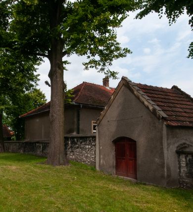 Zdjęcie nr 19: Kościół orientowany, murowany, jednonawowy z prezbiterium zakończonym wielobocznie. Wschodnia część węższa, prostokątna, zachodnia szersza, trójnawowa, halowa. Do prezbiterium od północy przylega zakrystia, do wschodniej części korpusu przybudówka, od zachodu kruchta. Ściany nawy dzielą pilastry. Prezbiterium sklepione krzyżowo, absyda konchowo z lunetami, nawy kolebkowo z lunetami. Od zachodu chór wsparty na dwóch czworobocznych słupach. Jego parapet jest wybrzuszony w części środkowej, ażurowy, zakończony u dołu listwą wycinaną w formie stylizowanych listków. W prezbiterium jedno okno w kształcie stojącego prostokąta zamknięte łukiem pełnym i jedno ślepe, zamknięte łukiem ostrym. Od strony  północnej do zakrystii dwa okna zamknięte łukiem odcinkowym i cztery prostokątne, dwa okna zamknięte łukiem pełnym do zachodniej części nawy; od strony południowej pięć okien zamkniętych łukiem pełnym. Główne wejście od zachodu, drugie od południa, kolejne do  zakrystii, portal z prezbiterium do zakrystii, z czarnego marmuru. Fasada dwuwieżowa, z kruchtą, do której prowadzi ciąg schodów. Kruchta prostopadłościenna, z dachem dwuspadowym, z portalem w kształcie prostokąta zamkniętego łukiem pełnym na osi między oknami powtarzającymi ten kształt. Nad kondygnacją trójkątny przyczółek z krzyżem łacińskim. Fasada dwukondygnacyjna, z wieżami wtopionymi w lico. Pierwsza kondygnacja gładka, flankowana szkarpami, zamknięta gzymsem, druga również niemal gładka, z zegarem na środku i małymi oknami w partii wież. Na osi trójkątny przyczółek. Elewacje obiega cokół, wspierają szkarpy – najgęściej ustawione wokół prezbiterium. Dachy naw dwuspadowe, nad prezbiterium dach zakończony wielobocznie, nad zakrystią pulpitowy; na kalenicy wieżyczka na sygnaturkę, wieże zakończone rozbudowanymi hełmami. 
We wnętrzu na uwagę zasługują chrzcielnica z czarnego marmuru z XVII wieku, obraz św. Izydora w prawym, bocznym ołtarzu według tradycji pędzla Michała Stachowicza i późnobarokowe ołtarze. Prowadzący do zakrystii portal z czarnego marmuru i ołtarz boczny lewy Ukrzyżowania pochodzą, według niektórych przekazów, z krakowskiego kościoła Wszystkich Świętych. 
