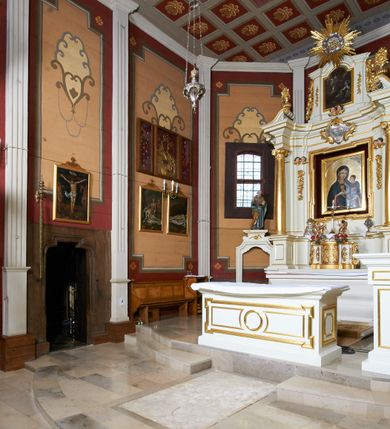 Zdjęcie nr 53: Kościół usytuowany jest w centrum wsi na niewielkim wzniesieniu, orientowany, drewniany, o konstrukcji zrębowej, oszalowany. Jego bryłę tworzy trójbocznie zamknięte prezbiterium, jednonawowy korpus, zakrystia skomunikowana ze skarbcem oraz kruchty od południa i zachodu. Całość pokrywają oddzielne dla nawy i prezbiterium dachy, nad nawą znajduje się wieżyczka na sygnaturkę. Wnętrza niższego, trójbocznie zamkniętego prezbiterium i szerszej, prawie kwadratowej nawy nakryte są stropem. Ściany kościoła zostały podzielone na przęsła kanelowanymi pilastrami ustawionymi na cokołach i zwieńczone profilowanym gzymsem, wyłamującym się na kapitelach. W prezbiterium znajdują się dwa okna od południa i dwa w bocznych ścianach wschodniego zamknięcia; korpus jest oświetlony od południa dwoma oknami. Wszystkie okna zamknięte są łukiem odcinkowym i umieszczone w prostokątnych obramieniach. Przestrzeń między prezbiterium a nawą jest nieznacznie zawężona wydatnymi pilastrami ustawionymi pod arkadą tęczową o łuku koszowym. W środkowym przęśle prezbiterium znajduje się wejście do północnej zakrystii, z profilowanym portalem zamkniętym łukiem trójlistnie ściętym. Na osi ściany południowej umieszczono prostokątny portal, ozdobiony od strony kruchty profilowaniem, a w nadprożu zdwojonym łukiem w  „ośli grzbiet”. Pod nim ornament arkadkowy i wyryta data „1547”. Główne wejście w ścianie zachodniej obejmuje profilowany od strony kruchty portal, który podobnie jak poprzedni zamknięty jest zdwojonym łukiem w „ośli grzbiet”. Chór muzyczny opiera się na dwóch kwadratowych słupach ustawionych diagonalnie (górą dekoracyjnie wycinanych), z parapetem o linii wklęsło-wypukłej. W południowo-zachodnim narożu znajdują się schody na chór osłonięte deskami. Zakrystia jest założona na rzucie prostokąta, przekryta pułapem, z lisicami na ścianie południowej i zachodniej. W osi ściany wschodniej zakrystii umieszczono okno zamknięte łukiem odcinkowym, a w narożu południowo-zachodnim schody na ambonę. W zachodniej ścianie zakrystii znajduje się prostokątne przejście do wąskiego przedsionka i dalej do dawnego skarbca przylegającego do korpusu. Kruchty są założone na rzucie prostokąta, wzdłużnie przylegającego do korpusu i przykryte stropem. Naprzeciw fasady ustawiono wolnostojącą, murowaną dzwonnicę.