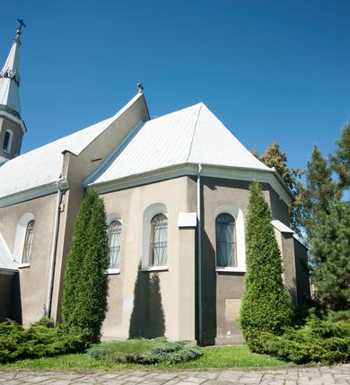 Zdjęcie nr 4: Kościół murowany, tynkowany, orientowany, jednonawowy. 
Prezbiterium prostokątne, zamknięte trójbocznie, od północy przylega zakrystia na planie prostokąta. Nawa szersza od prezbiterium, na rzucie prostokąta, od południa dostawiona kaplica Matki Boskiej na planie prostokąta, od zachodu wieża na planie kwadratu z dwoma aneksami po bokach. 
Prezbiterium dwuprzęsłowe, nawa trójprzęsłowa, nakryte sklepieniami krzyżowo-żebrowymi o gurtach spływających na profilowane wsporniki. Otwór tęczowy w formie półkolistej arkady. Parapet chóru muzycznego drewniany, wsparty na dwóch filarach.  Posadzka z płyt ceramicznych. 
Fasada wieżowa, jednoosiowa, trójkondygnacyjna, zwężająca się ku górze; dwie dolne kondygnacje na planie kwadratu, trzecia ośmioboku. Trzy ściany pierwszej kondygnacji wieży ujęte lizenami, zakończone profilowanym gzymsem z krenelażem oraz daszkiem pulpitowym. Na osi portal w formie stojącego prostokąta zamkniętego łukiem półkolistym, w opasce tynkowej z dwuskrzydłowymi drzwiami. Portal zamknięty od góry i po bokach uskokowym gzymsem z daszkiem pulpitowym. Nad portalem biforium. Trzy ściany drugiej kondygnacji wieży ujęte lizenami, zakończone profilowanym gzymsem z krenelażem oraz daszkiem pulpitowym. Na ścianach ślepe biforia we wnękach w formie stojącego prostokąta zamkniętego łukiem półkolistym. Trzecia kondygnacja zakończona profilowanym gzymsem z kostkowaniem, na ściankach otwory dzwonne w formie stojącego prostokąta zamkniętego łukiem półkolistym, naprzemiennie ślepe i otwarte. Wieża nakryta dachem ostrosłupowym. Po bokach wieży dwukondygnacyjne aneksy na planie wieloboku, przekryte daszkami wielospadowymi. 
Nawa i prezbiterium oszkarpowane w narożach jedno i dwuuskokowymi szkarpami nakrytymi daszkami. Na elewacji południowej pięć otworów okiennych w formie stojącego prostokąta zamkniętego łukiem półkolistym, z szerokim rozglifieniem. Na elewacji wschodniej dwa analogiczne okna, na północnej trzy. 
Nawa, kaplica i zakrystia nakryte dachami blaszanymi, dwuspadowymi, prezbiterium pięciospadowym. 