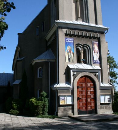 Zdjęcie nr 22: Kościół murowany, tynkowany, orientowany, jednonawowy. 
Prezbiterium prostokątne, zamknięte trójbocznie, od północy przylega zakrystia na planie prostokąta. Nawa szersza od prezbiterium, na rzucie prostokąta, od południa dostawiona kaplica Matki Boskiej na planie prostokąta, od zachodu wieża na planie kwadratu z dwoma aneksami po bokach. 
Prezbiterium dwuprzęsłowe, nawa trójprzęsłowa, nakryte sklepieniami krzyżowo-żebrowymi o gurtach spływających na profilowane wsporniki. Otwór tęczowy w formie półkolistej arkady. Parapet chóru muzycznego drewniany, wsparty na dwóch filarach.  Posadzka z płyt ceramicznych. 
Fasada wieżowa, jednoosiowa, trójkondygnacyjna, zwężająca się ku górze; dwie dolne kondygnacje na planie kwadratu, trzecia ośmioboku. Trzy ściany pierwszej kondygnacji wieży ujęte lizenami, zakończone profilowanym gzymsem z krenelażem oraz daszkiem pulpitowym. Na osi portal w formie stojącego prostokąta zamkniętego łukiem półkolistym, w opasce tynkowej z dwuskrzydłowymi drzwiami. Portal zamknięty od góry i po bokach uskokowym gzymsem z daszkiem pulpitowym. Nad portalem biforium. Trzy ściany drugiej kondygnacji wieży ujęte lizenami, zakończone profilowanym gzymsem z krenelażem oraz daszkiem pulpitowym. Na ścianach ślepe biforia we wnękach w formie stojącego prostokąta zamkniętego łukiem półkolistym. Trzecia kondygnacja zakończona profilowanym gzymsem z kostkowaniem, na ściankach otwory dzwonne w formie stojącego prostokąta zamkniętego łukiem półkolistym, naprzemiennie ślepe i otwarte. Wieża nakryta dachem ostrosłupowym. Po bokach wieży dwukondygnacyjne aneksy na planie wieloboku, przekryte daszkami wielospadowymi. 
Nawa i prezbiterium oszkarpowane w narożach jedno i dwuuskokowymi szkarpami nakrytymi daszkami. Na elewacji południowej pięć otworów okiennych w formie stojącego prostokąta zamkniętego łukiem półkolistym, z szerokim rozglifieniem. Na elewacji wschodniej dwa analogiczne okna, na północnej trzy. 
Nawa, kaplica i zakrystia nakryte dachami blaszanymi, dwuspadowymi, prezbiterium pięciospadowym. 