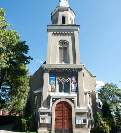 Zdjęcie nr 21: Kościół murowany, tynkowany, orientowany, jednonawowy. 
Prezbiterium prostokątne, zamknięte trójbocznie, od północy przylega zakrystia na planie prostokąta. Nawa szersza od prezbiterium, na rzucie prostokąta, od południa dostawiona kaplica Matki Boskiej na planie prostokąta, od zachodu wieża na planie kwadratu z dwoma aneksami po bokach. 
Prezbiterium dwuprzęsłowe, nawa trójprzęsłowa, nakryte sklepieniami krzyżowo-żebrowymi o gurtach spływających na profilowane wsporniki. Otwór tęczowy w formie półkolistej arkady. Parapet chóru muzycznego drewniany, wsparty na dwóch filarach.  Posadzka z płyt ceramicznych. 
Fasada wieżowa, jednoosiowa, trójkondygnacyjna, zwężająca się ku górze; dwie dolne kondygnacje na planie kwadratu, trzecia ośmioboku. Trzy ściany pierwszej kondygnacji wieży ujęte lizenami, zakończone profilowanym gzymsem z krenelażem oraz daszkiem pulpitowym. Na osi portal w formie stojącego prostokąta zamkniętego łukiem półkolistym, w opasce tynkowej z dwuskrzydłowymi drzwiami. Portal zamknięty od góry i po bokach uskokowym gzymsem z daszkiem pulpitowym. Nad portalem biforium. Trzy ściany drugiej kondygnacji wieży ujęte lizenami, zakończone profilowanym gzymsem z krenelażem oraz daszkiem pulpitowym. Na ścianach ślepe biforia we wnękach w formie stojącego prostokąta zamkniętego łukiem półkolistym. Trzecia kondygnacja zakończona profilowanym gzymsem z kostkowaniem, na ściankach otwory dzwonne w formie stojącego prostokąta zamkniętego łukiem półkolistym, naprzemiennie ślepe i otwarte. Wieża nakryta dachem ostrosłupowym. Po bokach wieży dwukondygnacyjne aneksy na planie wieloboku, przekryte daszkami wielospadowymi. 
Nawa i prezbiterium oszkarpowane w narożach jedno i dwuuskokowymi szkarpami nakrytymi daszkami. Na elewacji południowej pięć otworów okiennych w formie stojącego prostokąta zamkniętego łukiem półkolistym, z szerokim rozglifieniem. Na elewacji wschodniej dwa analogiczne okna, na północnej trzy. 
Nawa, kaplica i zakrystia nakryte dachami blaszanymi, dwuspadowymi, prezbiterium pięciospadowym. 