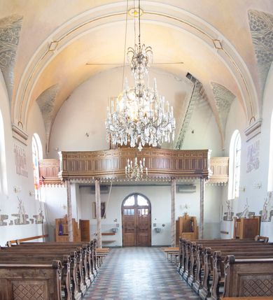 Zdjęcie nr 11: Kościół usytuowany w centrum wsi, u zbiegu głównych dróg, położony na niewielkim wzniesieniu, na placu otoczonym ogrodzeniem z kamiennymi filarami i metalową kratą. Budynek orientowany, jednonawowy, czteroprzęsłowy, z węższym prezbiterium zamkniętym trójbocznie. Od zachodu do fasady dostawiona niewielka kruchta; od południa dostawiona kaplica na planie prostokąta. Prezbiterium ujęte symetrycznie aneksami: pomieszczenie gospodarcze od północy i zakrystia od południa. Kościół sklepiony kolebkowo na gurtach z lunetami; prezbiterium nakryte sklepieniem parasolowatym; kaplica sklepieniem pseudoklasztornym; aneksy i kruchta z płaskim stropem. Wnętrze oświetlają prostokątne okna zamknięte półkoliście; w ścianie zachodniej okno okrągłe; w kaplicy i aneksach również okna zamknięte półkoliście. Wejście główne na osi kościoła, prostokątne; prezbiterium skomunikowane z aneksami prostokątnymi drzwiami; z zakrystii wyjście na zewnątrz. Chór muzyczny wsparty na czterech metalowych kolumnach z częścią środkową wybrzuszoną; z parapetem ozdobionym pseudopłycinami, kostkowaniem i  lambrekinem. Fasada jednoosiowa, jednokondygnacyjna z trójkątnym szczytem, ozdobiona krenelażem. Na osi kruchta, zamknięta trójkątnym szczytem z prostokątnym wejściem o półkolistym zwieńczeniu. Elewacje ujęte są uskokowymi przyporami i zwieńczone gzymsem z motywem lambrekinów. Dachy dwuspadowe nad nawą i prezbiterium; pulpitowe nad aneksami i kaplicą; kryte blachą. Dach wieńczy wieżyczka na sygnaturkę w formie gloriety zwieńczonej ostrosłupem z krzyżem.

Kaplica południowa na planie prostokąta, ze sklepieniem odwołującym się do formy sklepienia klasztornego. Szerokie wejście zakończone łukiem odcinkowym od strony nawy głównej. Naprzeciw wejścia okno zamknięte półkoliście, uskokowe wielokwaterowe. Wejście od strony zachodniej prostokątne, z drewnianymi drzwiami. Wnęka ołtarzowa zakończona łukiem półkolistym, z dekoracją mozaikową, przedstawiającą Michała Archanioła; podwieszona mensa ołtarzowa z lastriko. Część ołtarzowa podniesiona o jeden stopień.