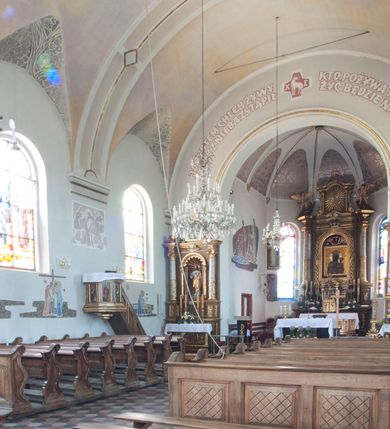 Zdjęcie nr 9: Kościół usytuowany w centrum wsi, u zbiegu głównych dróg, położony na niewielkim wzniesieniu, na placu otoczonym ogrodzeniem z kamiennymi filarami i metalową kratą. Budynek orientowany, jednonawowy, czteroprzęsłowy, z węższym prezbiterium zamkniętym trójbocznie. Od zachodu do fasady dostawiona niewielka kruchta; od południa dostawiona kaplica na planie prostokąta. Prezbiterium ujęte symetrycznie aneksami: pomieszczenie gospodarcze od północy i zakrystia od południa. Kościół sklepiony kolebkowo na gurtach z lunetami; prezbiterium nakryte sklepieniem parasolowatym; kaplica sklepieniem pseudoklasztornym; aneksy i kruchta z płaskim stropem. Wnętrze oświetlają prostokątne okna zamknięte półkoliście; w ścianie zachodniej okno okrągłe; w kaplicy i aneksach również okna zamknięte półkoliście. Wejście główne na osi kościoła, prostokątne; prezbiterium skomunikowane z aneksami prostokątnymi drzwiami; z zakrystii wyjście na zewnątrz. Chór muzyczny wsparty na czterech metalowych kolumnach z częścią środkową wybrzuszoną; z parapetem ozdobionym pseudopłycinami, kostkowaniem i  lambrekinem. Fasada jednoosiowa, jednokondygnacyjna z trójkątnym szczytem, ozdobiona krenelażem. Na osi kruchta, zamknięta trójkątnym szczytem z prostokątnym wejściem o półkolistym zwieńczeniu. Elewacje ujęte są uskokowymi przyporami i zwieńczone gzymsem z motywem lambrekinów. Dachy dwuspadowe nad nawą i prezbiterium; pulpitowe nad aneksami i kaplicą; kryte blachą. Dach wieńczy wieżyczka na sygnaturkę w formie gloriety zwieńczonej ostrosłupem z krzyżem.

Kaplica południowa na planie prostokąta, ze sklepieniem odwołującym się do formy sklepienia klasztornego. Szerokie wejście zakończone łukiem odcinkowym od strony nawy głównej. Naprzeciw wejścia okno zamknięte półkoliście, uskokowe wielokwaterowe. Wejście od strony zachodniej prostokątne, z drewnianymi drzwiami. Wnęka ołtarzowa zakończona łukiem półkolistym, z dekoracją mozaikową, przedstawiającą Michała Archanioła; podwieszona mensa ołtarzowa z lastriko. Część ołtarzowa podniesiona o jeden stopień.