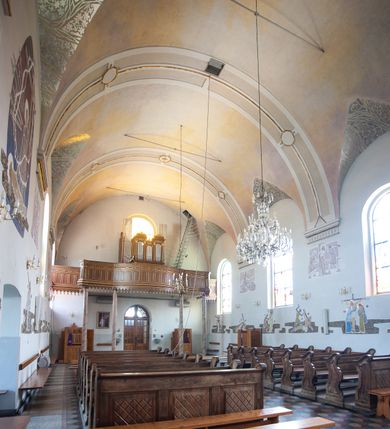 Zdjęcie nr 14: Kościół usytuowany w centrum wsi, u zbiegu głównych dróg, położony na niewielkim wzniesieniu, na placu otoczonym ogrodzeniem z kamiennymi filarami i metalową kratą. Budynek orientowany, jednonawowy, czteroprzęsłowy, z węższym prezbiterium zamkniętym trójbocznie. Od zachodu do fasady dostawiona niewielka kruchta; od południa dostawiona kaplica na planie prostokąta. Prezbiterium ujęte symetrycznie aneksami: pomieszczenie gospodarcze od północy i zakrystia od południa. Kościół sklepiony kolebkowo na gurtach z lunetami; prezbiterium nakryte sklepieniem parasolowatym; kaplica sklepieniem pseudoklasztornym; aneksy i kruchta z płaskim stropem. Wnętrze oświetlają prostokątne okna zamknięte półkoliście; w ścianie zachodniej okno okrągłe; w kaplicy i aneksach również okna zamknięte półkoliście. Wejście główne na osi kościoła, prostokątne; prezbiterium skomunikowane z aneksami prostokątnymi drzwiami; z zakrystii wyjście na zewnątrz. Chór muzyczny wsparty na czterech metalowych kolumnach z częścią środkową wybrzuszoną; z parapetem ozdobionym pseudopłycinami, kostkowaniem i  lambrekinem. Fasada jednoosiowa, jednokondygnacyjna z trójkątnym szczytem, ozdobiona krenelażem. Na osi kruchta, zamknięta trójkątnym szczytem z prostokątnym wejściem o półkolistym zwieńczeniu. Elewacje ujęte są uskokowymi przyporami i zwieńczone gzymsem z motywem lambrekinów. Dachy dwuspadowe nad nawą i prezbiterium; pulpitowe nad aneksami i kaplicą; kryte blachą. Dach wieńczy wieżyczka na sygnaturkę w formie gloriety zwieńczonej ostrosłupem z krzyżem.

Kaplica południowa na planie prostokąta, ze sklepieniem odwołującym się do formy sklepienia klasztornego. Szerokie wejście zakończone łukiem odcinkowym od strony nawy głównej. Naprzeciw wejścia okno zamknięte półkoliście, uskokowe wielokwaterowe. Wejście od strony zachodniej prostokątne, z drewnianymi drzwiami. Wnęka ołtarzowa zakończona łukiem półkolistym, z dekoracją mozaikową, przedstawiającą Michała Archanioła; podwieszona mensa ołtarzowa z lastriko. Część ołtarzowa podniesiona o jeden stopień.