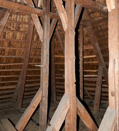 Zdjęcie nr 30: Kościół drewniany o konstrukcji zrębowej, na betonowym podmurowaniu przesłoniętym daszkiem gontowym, kruchta zachodnia o konstrukcji słupowo-ramowej. Elewacje jednolite, szalowane z listwowaniem, wzmocnione lisicami. Więźba dachowa drewniana, krokwiowa. Kościół orientowany, jednonawowy, nawa na rzucie prostokąta zbliżonego do kwadratu, prezbiterium nieco węższe, zakończone trójbocznie. Do wschodniej ściany prezbiterium przylega Ogrójec na rzucie prostokąta, od północy zakrystia na planie zbliżonym do trapezu. Do północnej ściany nawy przylega niewielka kruchta na rzucie prostokąta, od zachodu duża kruchta na planie prostokąta z pomieszczeniem nad nią, ze schodami drabiniastymi na chór, otwarta do nawy trzema dużymi otworami o wykroju prostokątnym. Wnętrze podzielone pilastrami podtrzymującymi architraw i fryz, wyłamane na ich osi. Pomiędzy nawą a prezbiterium prostokątny otwór tęczowy z prostą belką. Parapet chóru muzycznego w zachodniej części nawy, o wklęsło-wypukłym zarysie, podparty przez dwie kolumny i dwie półkolumny o wielobocznych trzonach. Otwory drzwiowe o prostokątnym wykroju zamknięte drzwiami spągowymi w północnej ścianie nawy oraz prezbiterium. Wnętrze nakryte pułapami deskowymi. Posadzka z płyt ceramicznych. 
Elewacja frontowa jednoosiowa, na osi wejście do kruchty z dwuskrzydłowymi drzwiami, w partii szczytu podwójne okno. W elewacji południowej cztery otwory okienne w formie stojącego prostokąta zamkniętego łukiem odcinkowym, dwa w nawie i dwa w prezbiterium oraz prostokątne, podwójne okno w kruchcie zachodniej, z krosnowymi oknami o drobnych podziałach kwaterowych. Elewacja północna z prostokątnym, podwójnym oknem w części kruchty zachodniej oraz z wejściami do kruchty północnej i do zakrystii o dwuskrzydłowych drzwiach. Na ścianie wschodniej prezbiterium Ogrójec w formie głębokiej szalowanej wnęki przesłoniętej daszkiem pulpitowym. Kościół nakryty dachami gontowymi dwuspadowymi, wyższym nad nawą, niższym nad prezbiterium, z kalenicą dekorowaną gontowym grzebieniem, nad zakrystią i kruchtą północną miękko modelowane dachy trójspadowe, kruchta zachodnia nakryta dachem dwuspadowym, półszczytowym. W połowie długości dachu nad nawą od strony prezbiterium wznosi się ponad kalenicą wieżyczka na sygnaturkę, na ośmiobocznym obitym blachą trzonie, z latarnią zwieńczoną niewielkim cebulastym hełmem.

 

