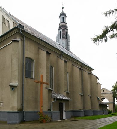 Zdjęcie nr 3: Kościół położony pośrodku wsi, na wysokiej skarpie, wzmocnionej murem. Otoczenie ogrodzone współcześnie. Od wschodu dzwonnica w formie bramy, ze schodami.  Kościół murowany, tynkowany, orientowany, zbudowany na planie wydłużonego prostokąta, jednonawowy, z węższym prezbiterium zamkniętym wielobocznie, opiętym szkarpami. Od północy przylega parterowa zakrystia z przedsionkiem, od południa dwie kruchty. Nawa od prezbiterium oddzielone ostrołukową arkadą. Wnętrze oświetlone oknami prostokątnymi zamkniętymi odcinkowo, wszystkie z witrażami. Nawa nakryta trójspadowym stropem, prezbiterium sklepieniem krzyżowo-żebrowym. Odrzwia z prezbiterium do zakrystii ostrołukowe. Okno w prezbiterium od wschodu ostrołukowe (zamurowane), okno w przedsionku zamknięte tzw. oślim grzbietem. Elewacje na kamiennym, obecnie tynkowanym cokole, oszkarpowane. Szkarpy uskokowe o zmiennym przekroju. Fasada jednoosiowa, zwieńczona trójkątnym szczytem. W osi elewacji ostrołukowy profilowany uskokowo portal, w szczycie okrągły otwór okienny, w płaskiej, tynkowanej opasce. Szczyt dodatkowo podzielony lizenami, u góry zdobiony fryzem arkadkowym, zamknięty wydatnym, profilowanym gzymsem. Oś elewacji zaakcentowana pośrodku wykonanym w tynku i zróżnicowanym kolorystycznie krzyżem, umieszczonym nad wejściem. Po lewej stronie portalu marmurowa tablica epitafijna. Po prawej stronie portalu marmurowa prostokątna tablica z donatorami. Elewacja zachodnia zamknięta wielobocznie, oszkarpowana. W górnej części ostrołukowa blenda, poniżej umieszczony krucyfiks, osłonięty dwuspadowym daszkiem, wspartym na konsolkach. Elewacje boczne pięcioosiowe z prostokątnymi otworami drzwiowymi w drugich osiach od zachodu. Poszczególne osie oddzielone prostokątnymi oknami. Zakrystia i kruchty nakryte dachem jednospadowym. Konstrukcja dachu korpusu głównego drewniana, krokwiowo-płatwiowa. Dach dwuspadowy, nad prezbiterium trójspadowy, kryty blachą ocynkowaną. Sygnaturka w całości obita blachą. Dzwonnica posiada dwie kondygnacje: dolną przeprutą dwiema arkadami, tworzącymi wejście w obręb cmentarza kościelnego i górną, przedzieloną czterema arkadami, przeznaczonymi na pomieszczenie dzwonów. Dach siodłowy.
