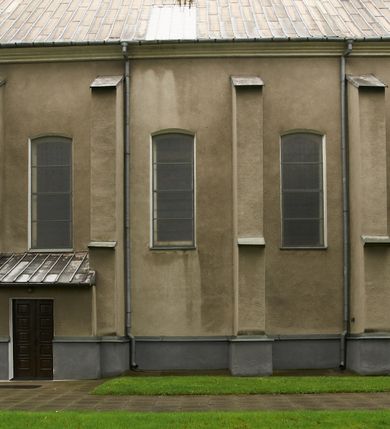 Zdjęcie nr 6: Kościół położony pośrodku wsi, na wysokiej skarpie, wzmocnionej murem. Otoczenie ogrodzone współcześnie. Od wschodu dzwonnica w formie bramy, ze schodami.  Kościół murowany, tynkowany, orientowany, zbudowany na planie wydłużonego prostokąta, jednonawowy, z węższym prezbiterium zamkniętym wielobocznie, opiętym szkarpami. Od północy przylega parterowa zakrystia z przedsionkiem, od południa dwie kruchty. Nawa od prezbiterium oddzielone ostrołukową arkadą. Wnętrze oświetlone oknami prostokątnymi zamkniętymi odcinkowo, wszystkie z witrażami. Nawa nakryta trójspadowym stropem, prezbiterium sklepieniem krzyżowo-żebrowym. Odrzwia z prezbiterium do zakrystii ostrołukowe. Okno w prezbiterium od wschodu ostrołukowe (zamurowane), okno w przedsionku zamknięte tzw. oślim grzbietem. Elewacje na kamiennym, obecnie tynkowanym cokole, oszkarpowane. Szkarpy uskokowe o zmiennym przekroju. Fasada jednoosiowa, zwieńczona trójkątnym szczytem. W osi elewacji ostrołukowy profilowany uskokowo portal, w szczycie okrągły otwór okienny, w płaskiej, tynkowanej opasce. Szczyt dodatkowo podzielony lizenami, u góry zdobiony fryzem arkadkowym, zamknięty wydatnym, profilowanym gzymsem. Oś elewacji zaakcentowana pośrodku wykonanym w tynku i zróżnicowanym kolorystycznie krzyżem, umieszczonym nad wejściem. Po lewej stronie portalu marmurowa tablica epitafijna. Po prawej stronie portalu marmurowa prostokątna tablica z donatorami. Elewacja zachodnia zamknięta wielobocznie, oszkarpowana. W górnej części ostrołukowa blenda, poniżej umieszczony krucyfiks, osłonięty dwuspadowym daszkiem, wspartym na konsolkach. Elewacje boczne pięcioosiowe z prostokątnymi otworami drzwiowymi w drugich osiach od zachodu. Poszczególne osie oddzielone prostokątnymi oknami. Zakrystia i kruchty nakryte dachem jednospadowym. Konstrukcja dachu korpusu głównego drewniana, krokwiowo-płatwiowa. Dach dwuspadowy, nad prezbiterium trójspadowy, kryty blachą ocynkowaną. Sygnaturka w całości obita blachą. Dzwonnica posiada dwie kondygnacje: dolną przeprutą dwiema arkadami, tworzącymi wejście w obręb cmentarza kościelnego i górną, przedzieloną czterema arkadami, przeznaczonymi na pomieszczenie dzwonów. Dach siodłowy.
