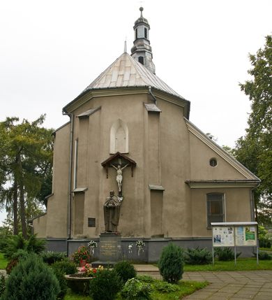 Zdjęcie nr 4: Kościół położony pośrodku wsi, na wysokiej skarpie, wzmocnionej murem. Otoczenie ogrodzone współcześnie. Od wschodu dzwonnica w formie bramy, ze schodami.  Kościół murowany, tynkowany, orientowany, zbudowany na planie wydłużonego prostokąta, jednonawowy, z węższym prezbiterium zamkniętym wielobocznie, opiętym szkarpami. Od północy przylega parterowa zakrystia z przedsionkiem, od południa dwie kruchty. Nawa od prezbiterium oddzielone ostrołukową arkadą. Wnętrze oświetlone oknami prostokątnymi zamkniętymi odcinkowo, wszystkie z witrażami. Nawa nakryta trójspadowym stropem, prezbiterium sklepieniem krzyżowo-żebrowym. Odrzwia z prezbiterium do zakrystii ostrołukowe. Okno w prezbiterium od wschodu ostrołukowe (zamurowane), okno w przedsionku zamknięte tzw. oślim grzbietem. Elewacje na kamiennym, obecnie tynkowanym cokole, oszkarpowane. Szkarpy uskokowe o zmiennym przekroju. Fasada jednoosiowa, zwieńczona trójkątnym szczytem. W osi elewacji ostrołukowy profilowany uskokowo portal, w szczycie okrągły otwór okienny, w płaskiej, tynkowanej opasce. Szczyt dodatkowo podzielony lizenami, u góry zdobiony fryzem arkadkowym, zamknięty wydatnym, profilowanym gzymsem. Oś elewacji zaakcentowana pośrodku wykonanym w tynku i zróżnicowanym kolorystycznie krzyżem, umieszczonym nad wejściem. Po lewej stronie portalu marmurowa tablica epitafijna. Po prawej stronie portalu marmurowa prostokątna tablica z donatorami. Elewacja zachodnia zamknięta wielobocznie, oszkarpowana. W górnej części ostrołukowa blenda, poniżej umieszczony krucyfiks, osłonięty dwuspadowym daszkiem, wspartym na konsolkach. Elewacje boczne pięcioosiowe z prostokątnymi otworami drzwiowymi w drugich osiach od zachodu. Poszczególne osie oddzielone prostokątnymi oknami. Zakrystia i kruchty nakryte dachem jednospadowym. Konstrukcja dachu korpusu głównego drewniana, krokwiowo-płatwiowa. Dach dwuspadowy, nad prezbiterium trójspadowy, kryty blachą ocynkowaną. Sygnaturka w całości obita blachą. Dzwonnica posiada dwie kondygnacje: dolną przeprutą dwiema arkadami, tworzącymi wejście w obręb cmentarza kościelnego i górną, przedzieloną czterema arkadami, przeznaczonymi na pomieszczenie dzwonów. Dach siodłowy.
