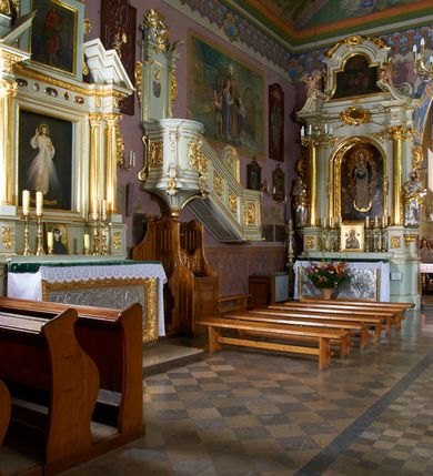 Zdjęcie nr 13: Kościół położony pośrodku wsi, na wysokiej skarpie, wzmocnionej murem. Otoczenie ogrodzone współcześnie. Od wschodu dzwonnica w formie bramy, ze schodami.  Kościół murowany, tynkowany, orientowany, zbudowany na planie wydłużonego prostokąta, jednonawowy, z węższym prezbiterium zamkniętym wielobocznie, opiętym szkarpami. Od północy przylega parterowa zakrystia z przedsionkiem, od południa dwie kruchty. Nawa od prezbiterium oddzielone ostrołukową arkadą. Wnętrze oświetlone oknami prostokątnymi zamkniętymi odcinkowo, wszystkie z witrażami. Nawa nakryta trójspadowym stropem, prezbiterium sklepieniem krzyżowo-żebrowym. Odrzwia z prezbiterium do zakrystii ostrołukowe. Okno w prezbiterium od wschodu ostrołukowe (zamurowane), okno w przedsionku zamknięte tzw. oślim grzbietem. Elewacje na kamiennym, obecnie tynkowanym cokole, oszkarpowane. Szkarpy uskokowe o zmiennym przekroju. Fasada jednoosiowa, zwieńczona trójkątnym szczytem. W osi elewacji ostrołukowy profilowany uskokowo portal, w szczycie okrągły otwór okienny, w płaskiej, tynkowanej opasce. Szczyt dodatkowo podzielony lizenami, u góry zdobiony fryzem arkadkowym, zamknięty wydatnym, profilowanym gzymsem. Oś elewacji zaakcentowana pośrodku wykonanym w tynku i zróżnicowanym kolorystycznie krzyżem, umieszczonym nad wejściem. Po lewej stronie portalu marmurowa tablica epitafijna. Po prawej stronie portalu marmurowa prostokątna tablica z donatorami. Elewacja zachodnia zamknięta wielobocznie, oszkarpowana. W górnej części ostrołukowa blenda, poniżej umieszczony krucyfiks, osłonięty dwuspadowym daszkiem, wspartym na konsolkach. Elewacje boczne pięcioosiowe z prostokątnymi otworami drzwiowymi w drugich osiach od zachodu. Poszczególne osie oddzielone prostokątnymi oknami. Zakrystia i kruchty nakryte dachem jednospadowym. Konstrukcja dachu korpusu głównego drewniana, krokwiowo-płatwiowa. Dach dwuspadowy, nad prezbiterium trójspadowy, kryty blachą ocynkowaną. Sygnaturka w całości obita blachą. Dzwonnica posiada dwie kondygnacje: dolną przeprutą dwiema arkadami, tworzącymi wejście w obręb cmentarza kościelnego i górną, przedzieloną czterema arkadami, przeznaczonymi na pomieszczenie dzwonów. Dach siodłowy.
