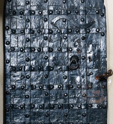 Zdjęcie nr 9: Kościół położony pośrodku wsi, na wysokiej skarpie, wzmocnionej murem. Otoczenie ogrodzone współcześnie. Od wschodu dzwonnica w formie bramy, ze schodami.  Kościół murowany, tynkowany, orientowany, zbudowany na planie wydłużonego prostokąta, jednonawowy, z węższym prezbiterium zamkniętym wielobocznie, opiętym szkarpami. Od północy przylega parterowa zakrystia z przedsionkiem, od południa dwie kruchty. Nawa od prezbiterium oddzielone ostrołukową arkadą. Wnętrze oświetlone oknami prostokątnymi zamkniętymi odcinkowo, wszystkie z witrażami. Nawa nakryta trójspadowym stropem, prezbiterium sklepieniem krzyżowo-żebrowym. Odrzwia z prezbiterium do zakrystii ostrołukowe. Okno w prezbiterium od wschodu ostrołukowe (zamurowane), okno w przedsionku zamknięte tzw. oślim grzbietem. Elewacje na kamiennym, obecnie tynkowanym cokole, oszkarpowane. Szkarpy uskokowe o zmiennym przekroju. Fasada jednoosiowa, zwieńczona trójkątnym szczytem. W osi elewacji ostrołukowy profilowany uskokowo portal, w szczycie okrągły otwór okienny, w płaskiej, tynkowanej opasce. Szczyt dodatkowo podzielony lizenami, u góry zdobiony fryzem arkadkowym, zamknięty wydatnym, profilowanym gzymsem. Oś elewacji zaakcentowana pośrodku wykonanym w tynku i zróżnicowanym kolorystycznie krzyżem, umieszczonym nad wejściem. Po lewej stronie portalu marmurowa tablica epitafijna. Po prawej stronie portalu marmurowa prostokątna tablica z donatorami. Elewacja zachodnia zamknięta wielobocznie, oszkarpowana. W górnej części ostrołukowa blenda, poniżej umieszczony krucyfiks, osłonięty dwuspadowym daszkiem, wspartym na konsolkach. Elewacje boczne pięcioosiowe z prostokątnymi otworami drzwiowymi w drugich osiach od zachodu. Poszczególne osie oddzielone prostokątnymi oknami. Zakrystia i kruchty nakryte dachem jednospadowym. Konstrukcja dachu korpusu głównego drewniana, krokwiowo-płatwiowa. Dach dwuspadowy, nad prezbiterium trójspadowy, kryty blachą ocynkowaną. Sygnaturka w całości obita blachą. Dzwonnica posiada dwie kondygnacje: dolną przeprutą dwiema arkadami, tworzącymi wejście w obręb cmentarza kościelnego i górną, przedzieloną czterema arkadami, przeznaczonymi na pomieszczenie dzwonów. Dach siodłowy.
