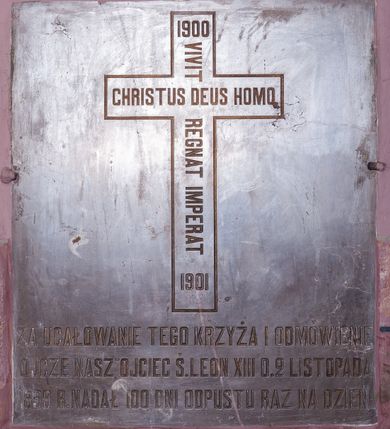 Zdjęcie nr 10: Kościół położony pośrodku wsi, na wysokiej skarpie, wzmocnionej murem. Otoczenie ogrodzone współcześnie. Od wschodu dzwonnica w formie bramy, ze schodami.  Kościół murowany, tynkowany, orientowany, zbudowany na planie wydłużonego prostokąta, jednonawowy, z węższym prezbiterium zamkniętym wielobocznie, opiętym szkarpami. Od północy przylega parterowa zakrystia z przedsionkiem, od południa dwie kruchty. Nawa od prezbiterium oddzielone ostrołukową arkadą. Wnętrze oświetlone oknami prostokątnymi zamkniętymi odcinkowo, wszystkie z witrażami. Nawa nakryta trójspadowym stropem, prezbiterium sklepieniem krzyżowo-żebrowym. Odrzwia z prezbiterium do zakrystii ostrołukowe. Okno w prezbiterium od wschodu ostrołukowe (zamurowane), okno w przedsionku zamknięte tzw. oślim grzbietem. Elewacje na kamiennym, obecnie tynkowanym cokole, oszkarpowane. Szkarpy uskokowe o zmiennym przekroju. Fasada jednoosiowa, zwieńczona trójkątnym szczytem. W osi elewacji ostrołukowy profilowany uskokowo portal, w szczycie okrągły otwór okienny, w płaskiej, tynkowanej opasce. Szczyt dodatkowo podzielony lizenami, u góry zdobiony fryzem arkadkowym, zamknięty wydatnym, profilowanym gzymsem. Oś elewacji zaakcentowana pośrodku wykonanym w tynku i zróżnicowanym kolorystycznie krzyżem, umieszczonym nad wejściem. Po lewej stronie portalu marmurowa tablica epitafijna. Po prawej stronie portalu marmurowa prostokątna tablica z donatorami. Elewacja zachodnia zamknięta wielobocznie, oszkarpowana. W górnej części ostrołukowa blenda, poniżej umieszczony krucyfiks, osłonięty dwuspadowym daszkiem, wspartym na konsolkach. Elewacje boczne pięcioosiowe z prostokątnymi otworami drzwiowymi w drugich osiach od zachodu. Poszczególne osie oddzielone prostokątnymi oknami. Zakrystia i kruchty nakryte dachem jednospadowym. Konstrukcja dachu korpusu głównego drewniana, krokwiowo-płatwiowa. Dach dwuspadowy, nad prezbiterium trójspadowy, kryty blachą ocynkowaną. Sygnaturka w całości obita blachą. Dzwonnica posiada dwie kondygnacje: dolną przeprutą dwiema arkadami, tworzącymi wejście w obręb cmentarza kościelnego i górną, przedzieloną czterema arkadami, przeznaczonymi na pomieszczenie dzwonów. Dach siodłowy.
