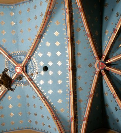 Zdjęcie nr 21: Kościół położony pośrodku wsi, na wysokiej skarpie, wzmocnionej murem. Otoczenie ogrodzone współcześnie. Od wschodu dzwonnica w formie bramy, ze schodami.  Kościół murowany, tynkowany, orientowany, zbudowany na planie wydłużonego prostokąta, jednonawowy, z węższym prezbiterium zamkniętym wielobocznie, opiętym szkarpami. Od północy przylega parterowa zakrystia z przedsionkiem, od południa dwie kruchty. Nawa od prezbiterium oddzielone ostrołukową arkadą. Wnętrze oświetlone oknami prostokątnymi zamkniętymi odcinkowo, wszystkie z witrażami. Nawa nakryta trójspadowym stropem, prezbiterium sklepieniem krzyżowo-żebrowym. Odrzwia z prezbiterium do zakrystii ostrołukowe. Okno w prezbiterium od wschodu ostrołukowe (zamurowane), okno w przedsionku zamknięte tzw. oślim grzbietem. Elewacje na kamiennym, obecnie tynkowanym cokole, oszkarpowane. Szkarpy uskokowe o zmiennym przekroju. Fasada jednoosiowa, zwieńczona trójkątnym szczytem. W osi elewacji ostrołukowy profilowany uskokowo portal, w szczycie okrągły otwór okienny, w płaskiej, tynkowanej opasce. Szczyt dodatkowo podzielony lizenami, u góry zdobiony fryzem arkadkowym, zamknięty wydatnym, profilowanym gzymsem. Oś elewacji zaakcentowana pośrodku wykonanym w tynku i zróżnicowanym kolorystycznie krzyżem, umieszczonym nad wejściem. Po lewej stronie portalu marmurowa tablica epitafijna. Po prawej stronie portalu marmurowa prostokątna tablica z donatorami. Elewacja zachodnia zamknięta wielobocznie, oszkarpowana. W górnej części ostrołukowa blenda, poniżej umieszczony krucyfiks, osłonięty dwuspadowym daszkiem, wspartym na konsolkach. Elewacje boczne pięcioosiowe z prostokątnymi otworami drzwiowymi w drugich osiach od zachodu. Poszczególne osie oddzielone prostokątnymi oknami. Zakrystia i kruchty nakryte dachem jednospadowym. Konstrukcja dachu korpusu głównego drewniana, krokwiowo-płatwiowa. Dach dwuspadowy, nad prezbiterium trójspadowy, kryty blachą ocynkowaną. Sygnaturka w całości obita blachą. Dzwonnica posiada dwie kondygnacje: dolną przeprutą dwiema arkadami, tworzącymi wejście w obręb cmentarza kościelnego i górną, przedzieloną czterema arkadami, przeznaczonymi na pomieszczenie dzwonów. Dach siodłowy.
