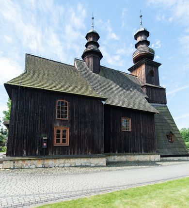 Zdjęcie nr 32: Kościół św. Andrzeja w Graboszycach usytuowany jest w centrum wsi, na wysokim wzniesieniu, przy bocznej drodze odchodzącej na zachód od drogi Wadowice-Zator. Plac kościelny otoczony jest drewnianym płotem na betonowej podmurówce i z murowanymi słupkami. W jego północno-wschodnim narożniku stoi drewniany krzyż. Po stronie południowej w miejscu dawnego cmentarza nagrobek dziedziców Graboszyc Aleksandra Chrząszcza (zm. 1868) i Emanuela Chrząszcza (zm. 1871). Na plac prowadzi wejście z dostępem schodami od strony zachodniej oraz drugie przez szeroką bramę od strony wschodnio-północnej. 

Kościół jest orientowany, konstrukcji zrębowej z wieżą na słup. Prezbiterium na planie prostokątnym, przy nim od północy piętrowa zakrystia. Nawa szersza kwadratowa z kruchtą od południa, od zachodu głęboka, prostokątna kruchta. Prezbiterium od nawy oddzielone ścianą arkady tęczowej, zamkniętą półkoliście z krucyfiksem na belce tęczowej. Chór muzyczny drewniany, wsparty na dwóch kolumnach z częścią środkową wysuniętą do przodu. Wewnątrz stropy, w prezbiterium ze skośnym szalowaniem po bokach, w nawie z zaskrzynieniami. Otwory okienne prostokątne, zamknięte łukiem odcinkowym, ulokowane od strony północnej oraz południowej. Wejście główne do świątyni prowadzi od strony zachodniej, a także od wschodu przez zakrystię i małą kruchtę od południa. 

W elewacji zewnętrznej kościoła wyróżnia się przysadzista czworoboczna wieża o ścianach pochyłych, pobitych gontem z nadwieszoną izbicą, nad izbicą nadbudowane później czworoboczne pięterko, hełm cebulasty z latarnią. Wokół kościoła kamienna podmurówka z nieregularnych płyt. Szalunek pionowy z listwowaniem. Prezbiterium niższe od nawy. Dachy, ściany i hełmy wieży oraz hełm wieżyczki na sygnaturkę gontowe. Dachy siodłowe, nad prezbiterium i zakrystią wspólne. 

