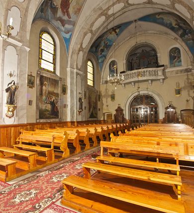 Zdjęcie nr 22: Kościół pw. Opieki Matki Boskiej w Kamieniu usytuowany jest na niewielkiej, wydzielonej ogrodzeniem działce usytuowanej na południe od głównej drogi wiodącej przez miejscowość. Kamieński kościół to budowla murowana z kamienia i cegły, orientowana, jednonawowa z nawą na rzucie prostokąta opiętą dziesięcioma trójuskokowymi przyporami oraz nieco węższym i półokrągło zamkniętym prezbiterium. Od strony północnej do prezbiterium przylega zakrystia na planie prostokąta. Do północno-zachodniej części nawy dostawiona jest niewielka, prostokątna kruchta. Wnętrze świątyni sklepiono sklepieniem kolebkowym z lunetami. Nawę i prezbiterium nakrywają dachy dwuspadowe, natomiast wieżę dach ostrosłupowy o czterech połaciach zwieńczony niewielkim krzyżem. Pierwotnie świątynia przekryta była dachem z czerwonej dachówki, którą w 1985 roku wymieniono na obecne pokrycie z ocynkowanej blachy. Więźbę dachową o konstrukcji płatwiowo-kleszczowej z krzyżującymi się stolcami wykonano z drewna sosnowego. Do wnętrza świątyni prowadzą trzy wejścia – główne z kruchtą od strony zachodniej, boczne również z kruchtą, z której wychodzi się na chór muzyczny i wieżę od strony północnej oraz wejście przez zakrystię. Do wejścia głównego prowadziły masywne, betonowe schody na rzucie półokręgu wylane w 1928 roku, które w 1981 roku zostały zastąpione obecnymi schodami na rzucie prostokąta. W trójosiowej i trójkondygnacyjnej fasadzie świątyni zaakcentowana wysunięciem do przodu jest oś środkowa przechodząca w górnej części w czworoboczną wieżę. W jej pierwszej kondygnacji mieści się zadaszony, opracowany w cegle, neobarokowy portal główny. Wieńczy go gzyms o kształcie łuku kotarowego, na szczycie którego znajduje się krzyż. W portalu umieszczone są dwuskrzydłowe, drewniane drzwi zamknięte łukiem półokrągłym. Ponad otworem wejściowym, w osi portalu znajduje się przeszklona rozeta. W kondygnacjach drugiej i trzeciej omawianej osi środkowej fasady mieszczą się półkoliście zamknięte okna. W osiach skrajnych nieregularnie rozmieszczono niewielkie, prostokątne okna, w kondygnacji pierwszej zamknięte półkoliście. Elewacje boczne świątyni są czteroosiowe i jednokondygnacyjne, z wyjątkiem trzykondygnacyjnej osi pierwszej, w której od strony północnej mieści się prostokątna kruchta, ponad którą rozmieszczono dwa półokrągło zamknięte okna, po jednym w kondygnacji drugiej i trzeciej. Od strony południowej we wszystkich kondygnacjach mieszczą się półokrągłe okna. Elewacje boczne nawy artykułowane są przyporami, pomiędzy którymi znajdują się okna zamknięte łukiem półokrągłym. W prezbiterium od strony wschodniej mieszczą się dwa półokrągłe okna.