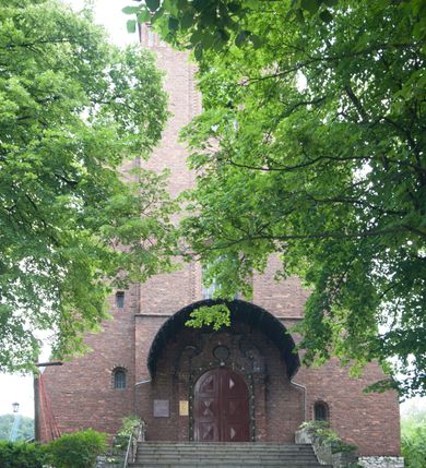 Zdjęcie nr 31: Kościół pw. Opieki Matki Boskiej w Kamieniu usytuowany jest na niewielkiej, wydzielonej ogrodzeniem działce usytuowanej na południe od głównej drogi wiodącej przez miejscowość. Kamieński kościół to budowla murowana z kamienia i cegły, orientowana, jednonawowa z nawą na rzucie prostokąta opiętą dziesięcioma trójuskokowymi przyporami oraz nieco węższym i półokrągło zamkniętym prezbiterium. Od strony północnej do prezbiterium przylega zakrystia na planie prostokąta. Do północno-zachodniej części nawy dostawiona jest niewielka, prostokątna kruchta. Wnętrze świątyni sklepiono sklepieniem kolebkowym z lunetami. Nawę i prezbiterium nakrywają dachy dwuspadowe, natomiast wieżę dach ostrosłupowy o czterech połaciach zwieńczony niewielkim krzyżem. Pierwotnie świątynia przekryta była dachem z czerwonej dachówki, którą w 1985 roku wymieniono na obecne pokrycie z ocynkowanej blachy. Więźbę dachową o konstrukcji płatwiowo-kleszczowej z krzyżującymi się stolcami wykonano z drewna sosnowego. Do wnętrza świątyni prowadzą trzy wejścia – główne z kruchtą od strony zachodniej, boczne również z kruchtą, z której wychodzi się na chór muzyczny i wieżę od strony północnej oraz wejście przez zakrystię. Do wejścia głównego prowadziły masywne, betonowe schody na rzucie półokręgu wylane w 1928 roku, które w 1981 roku zostały zastąpione obecnymi schodami na rzucie prostokąta. W trójosiowej i trójkondygnacyjnej fasadzie świątyni zaakcentowana wysunięciem do przodu jest oś środkowa przechodząca w górnej części w czworoboczną wieżę. W jej pierwszej kondygnacji mieści się zadaszony, opracowany w cegle, neobarokowy portal główny. Wieńczy go gzyms o kształcie łuku kotarowego, na szczycie którego znajduje się krzyż. W portalu umieszczone są dwuskrzydłowe, drewniane drzwi zamknięte łukiem półokrągłym. Ponad otworem wejściowym, w osi portalu znajduje się przeszklona rozeta. W kondygnacjach drugiej i trzeciej omawianej osi środkowej fasady mieszczą się półkoliście zamknięte okna. W osiach skrajnych nieregularnie rozmieszczono niewielkie, prostokątne okna, w kondygnacji pierwszej zamknięte półkoliście. Elewacje boczne świątyni są czteroosiowe i jednokondygnacyjne, z wyjątkiem trzykondygnacyjnej osi pierwszej, w której od strony północnej mieści się prostokątna kruchta, ponad którą rozmieszczono dwa półokrągło zamknięte okna, po jednym w kondygnacji drugiej i trzeciej. Od strony południowej we wszystkich kondygnacjach mieszczą się półokrągłe okna. Elewacje boczne nawy artykułowane są przyporami, pomiędzy którymi znajdują się okna zamknięte łukiem półokrągłym. W prezbiterium od strony wschodniej mieszczą się dwa półokrągłe okna.