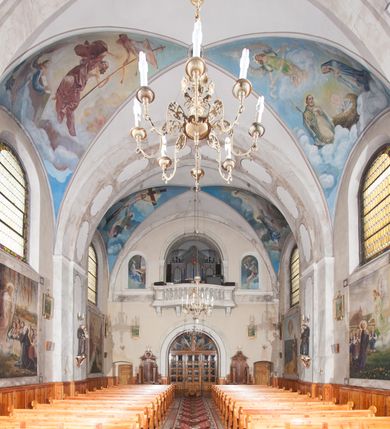 Zdjęcie nr 18: Kościół pw. Opieki Matki Boskiej w Kamieniu usytuowany jest na niewielkiej, wydzielonej ogrodzeniem działce usytuowanej na południe od głównej drogi wiodącej przez miejscowość. Kamieński kościół to budowla murowana z kamienia i cegły, orientowana, jednonawowa z nawą na rzucie prostokąta opiętą dziesięcioma trójuskokowymi przyporami oraz nieco węższym i półokrągło zamkniętym prezbiterium. Od strony północnej do prezbiterium przylega zakrystia na planie prostokąta. Do północno-zachodniej części nawy dostawiona jest niewielka, prostokątna kruchta. Wnętrze świątyni sklepiono sklepieniem kolebkowym z lunetami. Nawę i prezbiterium nakrywają dachy dwuspadowe, natomiast wieżę dach ostrosłupowy o czterech połaciach zwieńczony niewielkim krzyżem. Pierwotnie świątynia przekryta była dachem z czerwonej dachówki, którą w 1985 roku wymieniono na obecne pokrycie z ocynkowanej blachy. Więźbę dachową o konstrukcji płatwiowo-kleszczowej z krzyżującymi się stolcami wykonano z drewna sosnowego. Do wnętrza świątyni prowadzą trzy wejścia – główne z kruchtą od strony zachodniej, boczne również z kruchtą, z której wychodzi się na chór muzyczny i wieżę od strony północnej oraz wejście przez zakrystię. Do wejścia głównego prowadziły masywne, betonowe schody na rzucie półokręgu wylane w 1928 roku, które w 1981 roku zostały zastąpione obecnymi schodami na rzucie prostokąta. W trójosiowej i trójkondygnacyjnej fasadzie świątyni zaakcentowana wysunięciem do przodu jest oś środkowa przechodząca w górnej części w czworoboczną wieżę. W jej pierwszej kondygnacji mieści się zadaszony, opracowany w cegle, neobarokowy portal główny. Wieńczy go gzyms o kształcie łuku kotarowego, na szczycie którego znajduje się krzyż. W portalu umieszczone są dwuskrzydłowe, drewniane drzwi zamknięte łukiem półokrągłym. Ponad otworem wejściowym, w osi portalu znajduje się przeszklona rozeta. W kondygnacjach drugiej i trzeciej omawianej osi środkowej fasady mieszczą się półkoliście zamknięte okna. W osiach skrajnych nieregularnie rozmieszczono niewielkie, prostokątne okna, w kondygnacji pierwszej zamknięte półkoliście. Elewacje boczne świątyni są czteroosiowe i jednokondygnacyjne, z wyjątkiem trzykondygnacyjnej osi pierwszej, w której od strony północnej mieści się prostokątna kruchta, ponad którą rozmieszczono dwa półokrągło zamknięte okna, po jednym w kondygnacji drugiej i trzeciej. Od strony południowej we wszystkich kondygnacjach mieszczą się półokrągłe okna. Elewacje boczne nawy artykułowane są przyporami, pomiędzy którymi znajdują się okna zamknięte łukiem półokrągłym. W prezbiterium od strony wschodniej mieszczą się dwa półokrągłe okna.