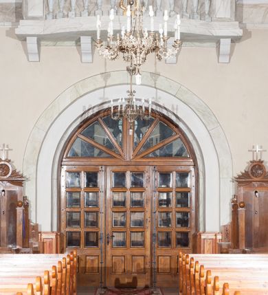 Zdjęcie nr 25: Kościół pw. Opieki Matki Boskiej w Kamieniu usytuowany jest na niewielkiej, wydzielonej ogrodzeniem działce usytuowanej na południe od głównej drogi wiodącej przez miejscowość. Kamieński kościół to budowla murowana z kamienia i cegły, orientowana, jednonawowa z nawą na rzucie prostokąta opiętą dziesięcioma trójuskokowymi przyporami oraz nieco węższym i półokrągło zamkniętym prezbiterium. Od strony północnej do prezbiterium przylega zakrystia na planie prostokąta. Do północno-zachodniej części nawy dostawiona jest niewielka, prostokątna kruchta. Wnętrze świątyni sklepiono sklepieniem kolebkowym z lunetami. Nawę i prezbiterium nakrywają dachy dwuspadowe, natomiast wieżę dach ostrosłupowy o czterech połaciach zwieńczony niewielkim krzyżem. Pierwotnie świątynia przekryta była dachem z czerwonej dachówki, którą w 1985 roku wymieniono na obecne pokrycie z ocynkowanej blachy. Więźbę dachową o konstrukcji płatwiowo-kleszczowej z krzyżującymi się stolcami wykonano z drewna sosnowego. Do wnętrza świątyni prowadzą trzy wejścia – główne z kruchtą od strony zachodniej, boczne również z kruchtą, z której wychodzi się na chór muzyczny i wieżę od strony północnej oraz wejście przez zakrystię. Do wejścia głównego prowadziły masywne, betonowe schody na rzucie półokręgu wylane w 1928 roku, które w 1981 roku zostały zastąpione obecnymi schodami na rzucie prostokąta. W trójosiowej i trójkondygnacyjnej fasadzie świątyni zaakcentowana wysunięciem do przodu jest oś środkowa przechodząca w górnej części w czworoboczną wieżę. W jej pierwszej kondygnacji mieści się zadaszony, opracowany w cegle, neobarokowy portal główny. Wieńczy go gzyms o kształcie łuku kotarowego, na szczycie którego znajduje się krzyż. W portalu umieszczone są dwuskrzydłowe, drewniane drzwi zamknięte łukiem półokrągłym. Ponad otworem wejściowym, w osi portalu znajduje się przeszklona rozeta. W kondygnacjach drugiej i trzeciej omawianej osi środkowej fasady mieszczą się półkoliście zamknięte okna. W osiach skrajnych nieregularnie rozmieszczono niewielkie, prostokątne okna, w kondygnacji pierwszej zamknięte półkoliście. Elewacje boczne świątyni są czteroosiowe i jednokondygnacyjne, z wyjątkiem trzykondygnacyjnej osi pierwszej, w której od strony północnej mieści się prostokątna kruchta, ponad którą rozmieszczono dwa półokrągło zamknięte okna, po jednym w kondygnacji drugiej i trzeciej. Od strony południowej we wszystkich kondygnacjach mieszczą się półokrągłe okna. Elewacje boczne nawy artykułowane są przyporami, pomiędzy którymi znajdują się okna zamknięte łukiem półokrągłym. W prezbiterium od strony wschodniej mieszczą się dwa półokrągłe okna.