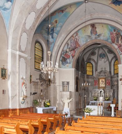 Zdjęcie nr 16: Kościół pw. Opieki Matki Boskiej w Kamieniu usytuowany jest na niewielkiej, wydzielonej ogrodzeniem działce usytuowanej na południe od głównej drogi wiodącej przez miejscowość. Kamieński kościół to budowla murowana z kamienia i cegły, orientowana, jednonawowa z nawą na rzucie prostokąta opiętą dziesięcioma trójuskokowymi przyporami oraz nieco węższym i półokrągło zamkniętym prezbiterium. Od strony północnej do prezbiterium przylega zakrystia na planie prostokąta. Do północno-zachodniej części nawy dostawiona jest niewielka, prostokątna kruchta. Wnętrze świątyni sklepiono sklepieniem kolebkowym z lunetami. Nawę i prezbiterium nakrywają dachy dwuspadowe, natomiast wieżę dach ostrosłupowy o czterech połaciach zwieńczony niewielkim krzyżem. Pierwotnie świątynia przekryta była dachem z czerwonej dachówki, którą w 1985 roku wymieniono na obecne pokrycie z ocynkowanej blachy. Więźbę dachową o konstrukcji płatwiowo-kleszczowej z krzyżującymi się stolcami wykonano z drewna sosnowego. Do wnętrza świątyni prowadzą trzy wejścia – główne z kruchtą od strony zachodniej, boczne również z kruchtą, z której wychodzi się na chór muzyczny i wieżę od strony północnej oraz wejście przez zakrystię. Do wejścia głównego prowadziły masywne, betonowe schody na rzucie półokręgu wylane w 1928 roku, które w 1981 roku zostały zastąpione obecnymi schodami na rzucie prostokąta. W trójosiowej i trójkondygnacyjnej fasadzie świątyni zaakcentowana wysunięciem do przodu jest oś środkowa przechodząca w górnej części w czworoboczną wieżę. W jej pierwszej kondygnacji mieści się zadaszony, opracowany w cegle, neobarokowy portal główny. Wieńczy go gzyms o kształcie łuku kotarowego, na szczycie którego znajduje się krzyż. W portalu umieszczone są dwuskrzydłowe, drewniane drzwi zamknięte łukiem półokrągłym. Ponad otworem wejściowym, w osi portalu znajduje się przeszklona rozeta. W kondygnacjach drugiej i trzeciej omawianej osi środkowej fasady mieszczą się półkoliście zamknięte okna. W osiach skrajnych nieregularnie rozmieszczono niewielkie, prostokątne okna, w kondygnacji pierwszej zamknięte półkoliście. Elewacje boczne świątyni są czteroosiowe i jednokondygnacyjne, z wyjątkiem trzykondygnacyjnej osi pierwszej, w której od strony północnej mieści się prostokątna kruchta, ponad którą rozmieszczono dwa półokrągło zamknięte okna, po jednym w kondygnacji drugiej i trzeciej. Od strony południowej we wszystkich kondygnacjach mieszczą się półokrągłe okna. Elewacje boczne nawy artykułowane są przyporami, pomiędzy którymi znajdują się okna zamknięte łukiem półokrągłym. W prezbiterium od strony wschodniej mieszczą się dwa półokrągłe okna.