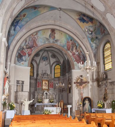 Zdjęcie nr 17: Kościół pw. Opieki Matki Boskiej w Kamieniu usytuowany jest na niewielkiej, wydzielonej ogrodzeniem działce usytuowanej na południe od głównej drogi wiodącej przez miejscowość. Kamieński kościół to budowla murowana z kamienia i cegły, orientowana, jednonawowa z nawą na rzucie prostokąta opiętą dziesięcioma trójuskokowymi przyporami oraz nieco węższym i półokrągło zamkniętym prezbiterium. Od strony północnej do prezbiterium przylega zakrystia na planie prostokąta. Do północno-zachodniej części nawy dostawiona jest niewielka, prostokątna kruchta. Wnętrze świątyni sklepiono sklepieniem kolebkowym z lunetami. Nawę i prezbiterium nakrywają dachy dwuspadowe, natomiast wieżę dach ostrosłupowy o czterech połaciach zwieńczony niewielkim krzyżem. Pierwotnie świątynia przekryta była dachem z czerwonej dachówki, którą w 1985 roku wymieniono na obecne pokrycie z ocynkowanej blachy. Więźbę dachową o konstrukcji płatwiowo-kleszczowej z krzyżującymi się stolcami wykonano z drewna sosnowego. Do wnętrza świątyni prowadzą trzy wejścia – główne z kruchtą od strony zachodniej, boczne również z kruchtą, z której wychodzi się na chór muzyczny i wieżę od strony północnej oraz wejście przez zakrystię. Do wejścia głównego prowadziły masywne, betonowe schody na rzucie półokręgu wylane w 1928 roku, które w 1981 roku zostały zastąpione obecnymi schodami na rzucie prostokąta. W trójosiowej i trójkondygnacyjnej fasadzie świątyni zaakcentowana wysunięciem do przodu jest oś środkowa przechodząca w górnej części w czworoboczną wieżę. W jej pierwszej kondygnacji mieści się zadaszony, opracowany w cegle, neobarokowy portal główny. Wieńczy go gzyms o kształcie łuku kotarowego, na szczycie którego znajduje się krzyż. W portalu umieszczone są dwuskrzydłowe, drewniane drzwi zamknięte łukiem półokrągłym. Ponad otworem wejściowym, w osi portalu znajduje się przeszklona rozeta. W kondygnacjach drugiej i trzeciej omawianej osi środkowej fasady mieszczą się półkoliście zamknięte okna. W osiach skrajnych nieregularnie rozmieszczono niewielkie, prostokątne okna, w kondygnacji pierwszej zamknięte półkoliście. Elewacje boczne świątyni są czteroosiowe i jednokondygnacyjne, z wyjątkiem trzykondygnacyjnej osi pierwszej, w której od strony północnej mieści się prostokątna kruchta, ponad którą rozmieszczono dwa półokrągło zamknięte okna, po jednym w kondygnacji drugiej i trzeciej. Od strony południowej we wszystkich kondygnacjach mieszczą się półokrągłe okna. Elewacje boczne nawy artykułowane są przyporami, pomiędzy którymi znajdują się okna zamknięte łukiem półokrągłym. W prezbiterium od strony wschodniej mieszczą się dwa półokrągłe okna.