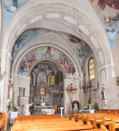 Zdjęcie nr 12: Kościół pw. Opieki Matki Boskiej w Kamieniu usytuowany jest na niewielkiej, wydzielonej ogrodzeniem działce usytuowanej na południe od głównej drogi wiodącej przez miejscowość. Kamieński kościół to budowla murowana z kamienia i cegły, orientowana, jednonawowa z nawą na rzucie prostokąta opiętą dziesięcioma trójuskokowymi przyporami oraz nieco węższym i półokrągło zamkniętym prezbiterium. Od strony północnej do prezbiterium przylega zakrystia na planie prostokąta. Do północno-zachodniej części nawy dostawiona jest niewielka, prostokątna kruchta. Wnętrze świątyni sklepiono sklepieniem kolebkowym z lunetami. Nawę i prezbiterium nakrywają dachy dwuspadowe, natomiast wieżę dach ostrosłupowy o czterech połaciach zwieńczony niewielkim krzyżem. Pierwotnie świątynia przekryta była dachem z czerwonej dachówki, którą w 1985 roku wymieniono na obecne pokrycie z ocynkowanej blachy. Więźbę dachową o konstrukcji płatwiowo-kleszczowej z krzyżującymi się stolcami wykonano z drewna sosnowego. Do wnętrza świątyni prowadzą trzy wejścia – główne z kruchtą od strony zachodniej, boczne również z kruchtą, z której wychodzi się na chór muzyczny i wieżę od strony północnej oraz wejście przez zakrystię. Do wejścia głównego prowadziły masywne, betonowe schody na rzucie półokręgu wylane w 1928 roku, które w 1981 roku zostały zastąpione obecnymi schodami na rzucie prostokąta. W trójosiowej i trójkondygnacyjnej fasadzie świątyni zaakcentowana wysunięciem do przodu jest oś środkowa przechodząca w górnej części w czworoboczną wieżę. W jej pierwszej kondygnacji mieści się zadaszony, opracowany w cegle, neobarokowy portal główny. Wieńczy go gzyms o kształcie łuku kotarowego, na szczycie którego znajduje się krzyż. W portalu umieszczone są dwuskrzydłowe, drewniane drzwi zamknięte łukiem półokrągłym. Ponad otworem wejściowym, w osi portalu znajduje się przeszklona rozeta. W kondygnacjach drugiej i trzeciej omawianej osi środkowej fasady mieszczą się półkoliście zamknięte okna. W osiach skrajnych nieregularnie rozmieszczono niewielkie, prostokątne okna, w kondygnacji pierwszej zamknięte półkoliście. Elewacje boczne świątyni są czteroosiowe i jednokondygnacyjne, z wyjątkiem trzykondygnacyjnej osi pierwszej, w której od strony północnej mieści się prostokątna kruchta, ponad którą rozmieszczono dwa półokrągło zamknięte okna, po jednym w kondygnacji drugiej i trzeciej. Od strony południowej we wszystkich kondygnacjach mieszczą się półokrągłe okna. Elewacje boczne nawy artykułowane są przyporami, pomiędzy którymi znajdują się okna zamknięte łukiem półokrągłym. W prezbiterium od strony wschodniej mieszczą się dwa półokrągłe okna.