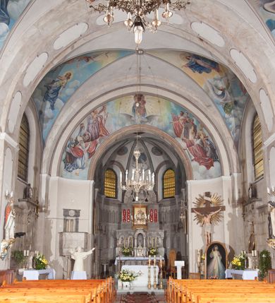 Zdjęcie nr 10: Kościół pw. Opieki Matki Boskiej w Kamieniu usytuowany jest na niewielkiej, wydzielonej ogrodzeniem działce usytuowanej na południe od głównej drogi wiodącej przez miejscowość. Kamieński kościół to budowla murowana z kamienia i cegły, orientowana, jednonawowa z nawą na rzucie prostokąta opiętą dziesięcioma trójuskokowymi przyporami oraz nieco węższym i półokrągło zamkniętym prezbiterium. Od strony północnej do prezbiterium przylega zakrystia na planie prostokąta. Do północno-zachodniej części nawy dostawiona jest niewielka, prostokątna kruchta. Wnętrze świątyni sklepiono sklepieniem kolebkowym z lunetami. Nawę i prezbiterium nakrywają dachy dwuspadowe, natomiast wieżę dach ostrosłupowy o czterech połaciach zwieńczony niewielkim krzyżem. Pierwotnie świątynia przekryta była dachem z czerwonej dachówki, którą w 1985 roku wymieniono na obecne pokrycie z ocynkowanej blachy. Więźbę dachową o konstrukcji płatwiowo-kleszczowej z krzyżującymi się stolcami wykonano z drewna sosnowego. Do wnętrza świątyni prowadzą trzy wejścia – główne z kruchtą od strony zachodniej, boczne również z kruchtą, z której wychodzi się na chór muzyczny i wieżę od strony północnej oraz wejście przez zakrystię. Do wejścia głównego prowadziły masywne, betonowe schody na rzucie półokręgu wylane w 1928 roku, które w 1981 roku zostały zastąpione obecnymi schodami na rzucie prostokąta. W trójosiowej i trójkondygnacyjnej fasadzie świątyni zaakcentowana wysunięciem do przodu jest oś środkowa przechodząca w górnej części w czworoboczną wieżę. W jej pierwszej kondygnacji mieści się zadaszony, opracowany w cegle, neobarokowy portal główny. Wieńczy go gzyms o kształcie łuku kotarowego, na szczycie którego znajduje się krzyż. W portalu umieszczone są dwuskrzydłowe, drewniane drzwi zamknięte łukiem półokrągłym. Ponad otworem wejściowym, w osi portalu znajduje się przeszklona rozeta. W kondygnacjach drugiej i trzeciej omawianej osi środkowej fasady mieszczą się półkoliście zamknięte okna. W osiach skrajnych nieregularnie rozmieszczono niewielkie, prostokątne okna, w kondygnacji pierwszej zamknięte półkoliście. Elewacje boczne świątyni są czteroosiowe i jednokondygnacyjne, z wyjątkiem trzykondygnacyjnej osi pierwszej, w której od strony północnej mieści się prostokątna kruchta, ponad którą rozmieszczono dwa półokrągło zamknięte okna, po jednym w kondygnacji drugiej i trzeciej. Od strony południowej we wszystkich kondygnacjach mieszczą się półokrągłe okna. Elewacje boczne nawy artykułowane są przyporami, pomiędzy którymi znajdują się okna zamknięte łukiem półokrągłym. W prezbiterium od strony wschodniej mieszczą się dwa półokrągłe okna.