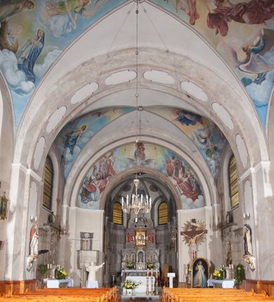 Zdjęcie nr 5: Kościół pw. Opieki Matki Boskiej w Kamieniu usytuowany jest na niewielkiej, wydzielonej ogrodzeniem działce usytuowanej na południe od głównej drogi wiodącej przez miejscowość. Kamieński kościół to budowla murowana z kamienia i cegły, orientowana, jednonawowa z nawą na rzucie prostokąta opiętą dziesięcioma trójuskokowymi przyporami oraz nieco węższym i półokrągło zamkniętym prezbiterium. Od strony północnej do prezbiterium przylega zakrystia na planie prostokąta. Do północno-zachodniej części nawy dostawiona jest niewielka, prostokątna kruchta. Wnętrze świątyni sklepiono sklepieniem kolebkowym z lunetami. Nawę i prezbiterium nakrywają dachy dwuspadowe, natomiast wieżę dach ostrosłupowy o czterech połaciach zwieńczony niewielkim krzyżem. Pierwotnie świątynia przekryta była dachem z czerwonej dachówki, którą w 1985 roku wymieniono na obecne pokrycie z ocynkowanej blachy. Więźbę dachową o konstrukcji płatwiowo-kleszczowej z krzyżującymi się stolcami wykonano z drewna sosnowego. Do wnętrza świątyni prowadzą trzy wejścia – główne z kruchtą od strony zachodniej, boczne również z kruchtą, z której wychodzi się na chór muzyczny i wieżę od strony północnej oraz wejście przez zakrystię. Do wejścia głównego prowadziły masywne, betonowe schody na rzucie półokręgu wylane w 1928 roku, które w 1981 roku zostały zastąpione obecnymi schodami na rzucie prostokąta. W trójosiowej i trójkondygnacyjnej fasadzie świątyni zaakcentowana wysunięciem do przodu jest oś środkowa przechodząca w górnej części w czworoboczną wieżę. W jej pierwszej kondygnacji mieści się zadaszony, opracowany w cegle, neobarokowy portal główny. Wieńczy go gzyms o kształcie łuku kotarowego, na szczycie którego znajduje się krzyż. W portalu umieszczone są dwuskrzydłowe, drewniane drzwi zamknięte łukiem półokrągłym. Ponad otworem wejściowym, w osi portalu znajduje się przeszklona rozeta. W kondygnacjach drugiej i trzeciej omawianej osi środkowej fasady mieszczą się półkoliście zamknięte okna. W osiach skrajnych nieregularnie rozmieszczono niewielkie, prostokątne okna, w kondygnacji pierwszej zamknięte półkoliście. Elewacje boczne świątyni są czteroosiowe i jednokondygnacyjne, z wyjątkiem trzykondygnacyjnej osi pierwszej, w której od strony północnej mieści się prostokątna kruchta, ponad którą rozmieszczono dwa półokrągło zamknięte okna, po jednym w kondygnacji drugiej i trzeciej. Od strony południowej we wszystkich kondygnacjach mieszczą się półokrągłe okna. Elewacje boczne nawy artykułowane są przyporami, pomiędzy którymi znajdują się okna zamknięte łukiem półokrągłym. W prezbiterium od strony wschodniej mieszczą się dwa półokrągłe okna.