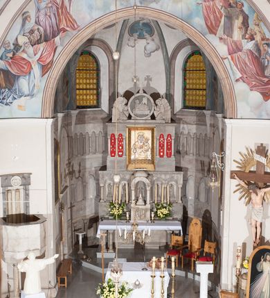 Zdjęcie nr 11: Kościół pw. Opieki Matki Boskiej w Kamieniu usytuowany jest na niewielkiej, wydzielonej ogrodzeniem działce usytuowanej na południe od głównej drogi wiodącej przez miejscowość. Kamieński kościół to budowla murowana z kamienia i cegły, orientowana, jednonawowa z nawą na rzucie prostokąta opiętą dziesięcioma trójuskokowymi przyporami oraz nieco węższym i półokrągło zamkniętym prezbiterium. Od strony północnej do prezbiterium przylega zakrystia na planie prostokąta. Do północno-zachodniej części nawy dostawiona jest niewielka, prostokątna kruchta. Wnętrze świątyni sklepiono sklepieniem kolebkowym z lunetami. Nawę i prezbiterium nakrywają dachy dwuspadowe, natomiast wieżę dach ostrosłupowy o czterech połaciach zwieńczony niewielkim krzyżem. Pierwotnie świątynia przekryta była dachem z czerwonej dachówki, którą w 1985 roku wymieniono na obecne pokrycie z ocynkowanej blachy. Więźbę dachową o konstrukcji płatwiowo-kleszczowej z krzyżującymi się stolcami wykonano z drewna sosnowego. Do wnętrza świątyni prowadzą trzy wejścia – główne z kruchtą od strony zachodniej, boczne również z kruchtą, z której wychodzi się na chór muzyczny i wieżę od strony północnej oraz wejście przez zakrystię. Do wejścia głównego prowadziły masywne, betonowe schody na rzucie półokręgu wylane w 1928 roku, które w 1981 roku zostały zastąpione obecnymi schodami na rzucie prostokąta. W trójosiowej i trójkondygnacyjnej fasadzie świątyni zaakcentowana wysunięciem do przodu jest oś środkowa przechodząca w górnej części w czworoboczną wieżę. W jej pierwszej kondygnacji mieści się zadaszony, opracowany w cegle, neobarokowy portal główny. Wieńczy go gzyms o kształcie łuku kotarowego, na szczycie którego znajduje się krzyż. W portalu umieszczone są dwuskrzydłowe, drewniane drzwi zamknięte łukiem półokrągłym. Ponad otworem wejściowym, w osi portalu znajduje się przeszklona rozeta. W kondygnacjach drugiej i trzeciej omawianej osi środkowej fasady mieszczą się półkoliście zamknięte okna. W osiach skrajnych nieregularnie rozmieszczono niewielkie, prostokątne okna, w kondygnacji pierwszej zamknięte półkoliście. Elewacje boczne świątyni są czteroosiowe i jednokondygnacyjne, z wyjątkiem trzykondygnacyjnej osi pierwszej, w której od strony północnej mieści się prostokątna kruchta, ponad którą rozmieszczono dwa półokrągło zamknięte okna, po jednym w kondygnacji drugiej i trzeciej. Od strony południowej we wszystkich kondygnacjach mieszczą się półokrągłe okna. Elewacje boczne nawy artykułowane są przyporami, pomiędzy którymi znajdują się okna zamknięte łukiem półokrągłym. W prezbiterium od strony wschodniej mieszczą się dwa półokrągłe okna.