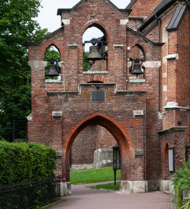 Zdjęcie nr 8: Kościół jest zlokalizowany na wzgórzu, w centrum wsi. Murowany z cegły, w wątku polskim, z zendrówką. Kościół jest orientowany, założony na planie prostokąta, jednonawowy, trójprzęsłowy, z dobudowanymi kruchtami od zachodu i południa. Prezbiterium oddzielone od nawy łukiem tęczowym, dwuprzęsłowe na planie prostokąta, zamknięte prostą ścianą, z dwukondygnacyjną przybudówką zakończoną trójbocznie. Nawa została przykryta sklepieniem sieciowym. Ściana południowa nawy przepruta trzema prostokątnymi oknami, zamkniętymi łukiem ostrym. Okna w nawie i prezbiterium dwudzielne, z sześcioma mniejszymi kwaterami. Przybudówka przy prezbiterium na parterze mieści zakrystię, a na piętrze składzik. Kruchta południowa sklepiona kolebką. Z kruchty do nawy prowadzi ostrołukowy, kamienny portal o dwóch archiwoltach. Kruchta zachodnia, obecnie kaplica św. Franciszka, sklepiona spłaszczoną, ukrytą kopułą na pendentywach. Ściana zachodnia kruchty przepruta dwoma ostrołukowymi oknami i ponad nimi okrągłym oknem. Od południa ostrołukowe wejście. Kościół o zróżnicowanej wysokości nawy i prezbiterium. Ściany opięte szkarpami. Na jednej trzeciej wysokości ścian oraz w zwieńczeniu nawy i prezbiterium profilowany gzyms. Od zachodu wklęsło-wypukły szczyt. Nawa, prezbiterium i dwie kruchty przykryte dachem dwuspadowym. Nad drugim przęsłem prezbiterium wieżyczka na sygnaturkę na planie ośmioboku, z profilowanym gzymsem i latarnią, zwieńczoną hełmem z kulą i krzyżem. Wejście do kościoła od południa i zachodu. Okna nawy i prezbiterium z kamiennym obramieniem. Nad wejściem do kruchty południowej formowany w cegle ostry łuk. Analogiczny łuk nad oknami w ścianie zachodniej i nad blendą w ścianie północnej. W przybudówce do prezbiterium dwie kondygnacje okien zamkniętych łukiem ostrym. W ścianie frontowej prostokątne wejście, a nad nim półkoliście zamknięta wnęka z grupą Ukrzyżowania. 


