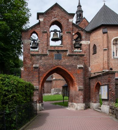 Zdjęcie nr 4: Kościół jest zlokalizowany na wzgórzu, w centrum wsi. Murowany z cegły, w wątku polskim, z zendrówką. Kościół jest orientowany, założony na planie prostokąta, jednonawowy, trójprzęsłowy, z dobudowanymi kruchtami od zachodu i południa. Prezbiterium oddzielone od nawy łukiem tęczowym, dwuprzęsłowe na planie prostokąta, zamknięte prostą ścianą, z dwukondygnacyjną przybudówką zakończoną trójbocznie. Nawa została przykryta sklepieniem sieciowym. Ściana południowa nawy przepruta trzema prostokątnymi oknami, zamkniętymi łukiem ostrym. Okna w nawie i prezbiterium dwudzielne, z sześcioma mniejszymi kwaterami. Przybudówka przy prezbiterium na parterze mieści zakrystię, a na piętrze składzik. Kruchta południowa sklepiona kolebką. Z kruchty do nawy prowadzi ostrołukowy, kamienny portal o dwóch archiwoltach. Kruchta zachodnia, obecnie kaplica św. Franciszka, sklepiona spłaszczoną, ukrytą kopułą na pendentywach. Ściana zachodnia kruchty przepruta dwoma ostrołukowymi oknami i ponad nimi okrągłym oknem. Od południa ostrołukowe wejście. Kościół o zróżnicowanej wysokości nawy i prezbiterium. Ściany opięte szkarpami. Na jednej trzeciej wysokości ścian oraz w zwieńczeniu nawy i prezbiterium profilowany gzyms. Od zachodu wklęsło-wypukły szczyt. Nawa, prezbiterium i dwie kruchty przykryte dachem dwuspadowym. Nad drugim przęsłem prezbiterium wieżyczka na sygnaturkę na planie ośmioboku, z profilowanym gzymsem i latarnią, zwieńczoną hełmem z kulą i krzyżem. Wejście do kościoła od południa i zachodu. Okna nawy i prezbiterium z kamiennym obramieniem. Nad wejściem do kruchty południowej formowany w cegle ostry łuk. Analogiczny łuk nad oknami w ścianie zachodniej i nad blendą w ścianie północnej. W przybudówce do prezbiterium dwie kondygnacje okien zamkniętych łukiem ostrym. W ścianie frontowej prostokątne wejście, a nad nim półkoliście zamknięta wnęka z grupą Ukrzyżowania. 


