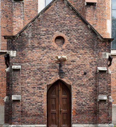 Zdjęcie nr 46: Kościół jest zlokalizowany na wzgórzu, w centrum wsi. Murowany z cegły, w wątku polskim, z zendrówką. Kościół jest orientowany, założony na planie prostokąta, jednonawowy, trójprzęsłowy, z dobudowanymi kruchtami od zachodu i południa. Prezbiterium oddzielone od nawy łukiem tęczowym, dwuprzęsłowe na planie prostokąta, zamknięte prostą ścianą, z dwukondygnacyjną przybudówką zakończoną trójbocznie. Nawa została przykryta sklepieniem sieciowym. Ściana południowa nawy przepruta trzema prostokątnymi oknami, zamkniętymi łukiem ostrym. Okna w nawie i prezbiterium dwudzielne, z sześcioma mniejszymi kwaterami. Przybudówka przy prezbiterium na parterze mieści zakrystię, a na piętrze składzik. Kruchta południowa sklepiona kolebką. Z kruchty do nawy prowadzi ostrołukowy, kamienny portal o dwóch archiwoltach. Kruchta zachodnia, obecnie kaplica św. Franciszka, sklepiona spłaszczoną, ukrytą kopułą na pendentywach. Ściana zachodnia kruchty przepruta dwoma ostrołukowymi oknami i ponad nimi okrągłym oknem. Od południa ostrołukowe wejście. Kościół o zróżnicowanej wysokości nawy i prezbiterium. Ściany opięte szkarpami. Na jednej trzeciej wysokości ścian oraz w zwieńczeniu nawy i prezbiterium profilowany gzyms. Od zachodu wklęsło-wypukły szczyt. Nawa, prezbiterium i dwie kruchty przykryte dachem dwuspadowym. Nad drugim przęsłem prezbiterium wieżyczka na sygnaturkę na planie ośmioboku, z profilowanym gzymsem i latarnią, zwieńczoną hełmem z kulą i krzyżem. Wejście do kościoła od południa i zachodu. Okna nawy i prezbiterium z kamiennym obramieniem. Nad wejściem do kruchty południowej formowany w cegle ostry łuk. Analogiczny łuk nad oknami w ścianie zachodniej i nad blendą w ścianie północnej. W przybudówce do prezbiterium dwie kondygnacje okien zamkniętych łukiem ostrym. W ścianie frontowej prostokątne wejście, a nad nim półkoliście zamknięta wnęka z grupą Ukrzyżowania. 


