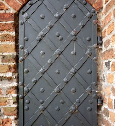 Zdjęcie nr 65: Kościół jest zlokalizowany na wzgórzu, w centrum wsi. Murowany z cegły, w wątku polskim, z zendrówką. Kościół jest orientowany, założony na planie prostokąta, jednonawowy, trójprzęsłowy, z dobudowanymi kruchtami od zachodu i południa. Prezbiterium oddzielone od nawy łukiem tęczowym, dwuprzęsłowe na planie prostokąta, zamknięte prostą ścianą, z dwukondygnacyjną przybudówką zakończoną trójbocznie. Nawa została przykryta sklepieniem sieciowym. Ściana południowa nawy przepruta trzema prostokątnymi oknami, zamkniętymi łukiem ostrym. Okna w nawie i prezbiterium dwudzielne, z sześcioma mniejszymi kwaterami. Przybudówka przy prezbiterium na parterze mieści zakrystię, a na piętrze składzik. Kruchta południowa sklepiona kolebką. Z kruchty do nawy prowadzi ostrołukowy, kamienny portal o dwóch archiwoltach. Kruchta zachodnia, obecnie kaplica św. Franciszka, sklepiona spłaszczoną, ukrytą kopułą na pendentywach. Ściana zachodnia kruchty przepruta dwoma ostrołukowymi oknami i ponad nimi okrągłym oknem. Od południa ostrołukowe wejście. Kościół o zróżnicowanej wysokości nawy i prezbiterium. Ściany opięte szkarpami. Na jednej trzeciej wysokości ścian oraz w zwieńczeniu nawy i prezbiterium profilowany gzyms. Od zachodu wklęsło-wypukły szczyt. Nawa, prezbiterium i dwie kruchty przykryte dachem dwuspadowym. Nad drugim przęsłem prezbiterium wieżyczka na sygnaturkę na planie ośmioboku, z profilowanym gzymsem i latarnią, zwieńczoną hełmem z kulą i krzyżem. Wejście do kościoła od południa i zachodu. Okna nawy i prezbiterium z kamiennym obramieniem. Nad wejściem do kruchty południowej formowany w cegle ostry łuk. Analogiczny łuk nad oknami w ścianie zachodniej i nad blendą w ścianie północnej. W przybudówce do prezbiterium dwie kondygnacje okien zamkniętych łukiem ostrym. W ścianie frontowej prostokątne wejście, a nad nim półkoliście zamknięta wnęka z grupą Ukrzyżowania. 


