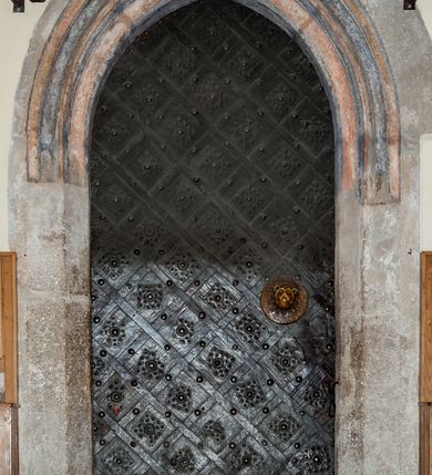 Zdjęcie nr 66: Kościół jest zlokalizowany na wzgórzu, w centrum wsi. Murowany z cegły, w wątku polskim, z zendrówką. Kościół jest orientowany, założony na planie prostokąta, jednonawowy, trójprzęsłowy, z dobudowanymi kruchtami od zachodu i południa. Prezbiterium oddzielone od nawy łukiem tęczowym, dwuprzęsłowe na planie prostokąta, zamknięte prostą ścianą, z dwukondygnacyjną przybudówką zakończoną trójbocznie. Nawa została przykryta sklepieniem sieciowym. Ściana południowa nawy przepruta trzema prostokątnymi oknami, zamkniętymi łukiem ostrym. Okna w nawie i prezbiterium dwudzielne, z sześcioma mniejszymi kwaterami. Przybudówka przy prezbiterium na parterze mieści zakrystię, a na piętrze składzik. Kruchta południowa sklepiona kolebką. Z kruchty do nawy prowadzi ostrołukowy, kamienny portal o dwóch archiwoltach. Kruchta zachodnia, obecnie kaplica św. Franciszka, sklepiona spłaszczoną, ukrytą kopułą na pendentywach. Ściana zachodnia kruchty przepruta dwoma ostrołukowymi oknami i ponad nimi okrągłym oknem. Od południa ostrołukowe wejście. Kościół o zróżnicowanej wysokości nawy i prezbiterium. Ściany opięte szkarpami. Na jednej trzeciej wysokości ścian oraz w zwieńczeniu nawy i prezbiterium profilowany gzyms. Od zachodu wklęsło-wypukły szczyt. Nawa, prezbiterium i dwie kruchty przykryte dachem dwuspadowym. Nad drugim przęsłem prezbiterium wieżyczka na sygnaturkę na planie ośmioboku, z profilowanym gzymsem i latarnią, zwieńczoną hełmem z kulą i krzyżem. Wejście do kościoła od południa i zachodu. Okna nawy i prezbiterium z kamiennym obramieniem. Nad wejściem do kruchty południowej formowany w cegle ostry łuk. Analogiczny łuk nad oknami w ścianie zachodniej i nad blendą w ścianie północnej. W przybudówce do prezbiterium dwie kondygnacje okien zamkniętych łukiem ostrym. W ścianie frontowej prostokątne wejście, a nad nim półkoliście zamknięta wnęka z grupą Ukrzyżowania. 


