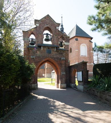 Zdjęcie nr 3: Kościół jest zlokalizowany na wzgórzu, w centrum wsi. Murowany z cegły, w wątku polskim, z zendrówką. Kościół jest orientowany, założony na planie prostokąta, jednonawowy, trójprzęsłowy, z dobudowanymi kruchtami od zachodu i południa. Prezbiterium oddzielone od nawy łukiem tęczowym, dwuprzęsłowe na planie prostokąta, zamknięte prostą ścianą, z dwukondygnacyjną przybudówką zakończoną trójbocznie. Nawa została przykryta sklepieniem sieciowym. Ściana południowa nawy przepruta trzema prostokątnymi oknami, zamkniętymi łukiem ostrym. Okna w nawie i prezbiterium dwudzielne, z sześcioma mniejszymi kwaterami. Przybudówka przy prezbiterium na parterze mieści zakrystię, a na piętrze składzik. Kruchta południowa sklepiona kolebką. Z kruchty do nawy prowadzi ostrołukowy, kamienny portal o dwóch archiwoltach. Kruchta zachodnia, obecnie kaplica św. Franciszka, sklepiona spłaszczoną, ukrytą kopułą na pendentywach. Ściana zachodnia kruchty przepruta dwoma ostrołukowymi oknami i ponad nimi okrągłym oknem. Od południa ostrołukowe wejście. Kościół o zróżnicowanej wysokości nawy i prezbiterium. Ściany opięte szkarpami. Na jednej trzeciej wysokości ścian oraz w zwieńczeniu nawy i prezbiterium profilowany gzyms. Od zachodu wklęsło-wypukły szczyt. Nawa, prezbiterium i dwie kruchty przykryte dachem dwuspadowym. Nad drugim przęsłem prezbiterium wieżyczka na sygnaturkę na planie ośmioboku, z profilowanym gzymsem i latarnią, zwieńczoną hełmem z kulą i krzyżem. Wejście do kościoła od południa i zachodu. Okna nawy i prezbiterium z kamiennym obramieniem. Nad wejściem do kruchty południowej formowany w cegle ostry łuk. Analogiczny łuk nad oknami w ścianie zachodniej i nad blendą w ścianie północnej. W przybudówce do prezbiterium dwie kondygnacje okien zamkniętych łukiem ostrym. W ścianie frontowej prostokątne wejście, a nad nim półkoliście zamknięta wnęka z grupą Ukrzyżowania. 


