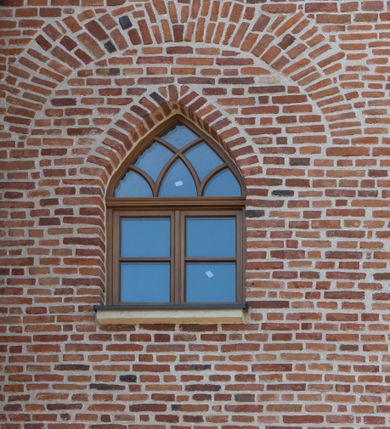 Zdjęcie nr 72: Kościół jest zlokalizowany na wzgórzu, w centrum wsi. Murowany z cegły, w wątku polskim, z zendrówką. Kościół jest orientowany, założony na planie prostokąta, jednonawowy, trójprzęsłowy, z dobudowanymi kruchtami od zachodu i południa. Prezbiterium oddzielone od nawy łukiem tęczowym, dwuprzęsłowe na planie prostokąta, zamknięte prostą ścianą, z dwukondygnacyjną przybudówką zakończoną trójbocznie. Nawa została przykryta sklepieniem sieciowym. Ściana południowa nawy przepruta trzema prostokątnymi oknami, zamkniętymi łukiem ostrym. Okna w nawie i prezbiterium dwudzielne, z sześcioma mniejszymi kwaterami. Przybudówka przy prezbiterium na parterze mieści zakrystię, a na piętrze składzik. Kruchta południowa sklepiona kolebką. Z kruchty do nawy prowadzi ostrołukowy, kamienny portal o dwóch archiwoltach. Kruchta zachodnia, obecnie kaplica św. Franciszka, sklepiona spłaszczoną, ukrytą kopułą na pendentywach. Ściana zachodnia kruchty przepruta dwoma ostrołukowymi oknami i ponad nimi okrągłym oknem. Od południa ostrołukowe wejście. Kościół o zróżnicowanej wysokości nawy i prezbiterium. Ściany opięte szkarpami. Na jednej trzeciej wysokości ścian oraz w zwieńczeniu nawy i prezbiterium profilowany gzyms. Od zachodu wklęsło-wypukły szczyt. Nawa, prezbiterium i dwie kruchty przykryte dachem dwuspadowym. Nad drugim przęsłem prezbiterium wieżyczka na sygnaturkę na planie ośmioboku, z profilowanym gzymsem i latarnią, zwieńczoną hełmem z kulą i krzyżem. Wejście do kościoła od południa i zachodu. Okna nawy i prezbiterium z kamiennym obramieniem. Nad wejściem do kruchty południowej formowany w cegle ostry łuk. Analogiczny łuk nad oknami w ścianie zachodniej i nad blendą w ścianie północnej. W przybudówce do prezbiterium dwie kondygnacje okien zamkniętych łukiem ostrym. W ścianie frontowej prostokątne wejście, a nad nim półkoliście zamknięta wnęka z grupą Ukrzyżowania. 


