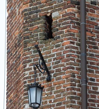 Zdjęcie nr 59: Kościół jest zlokalizowany na wzgórzu, w centrum wsi. Murowany z cegły, w wątku polskim, z zendrówką. Kościół jest orientowany, założony na planie prostokąta, jednonawowy, trójprzęsłowy, z dobudowanymi kruchtami od zachodu i południa. Prezbiterium oddzielone od nawy łukiem tęczowym, dwuprzęsłowe na planie prostokąta, zamknięte prostą ścianą, z dwukondygnacyjną przybudówką zakończoną trójbocznie. Nawa została przykryta sklepieniem sieciowym. Ściana południowa nawy przepruta trzema prostokątnymi oknami, zamkniętymi łukiem ostrym. Okna w nawie i prezbiterium dwudzielne, z sześcioma mniejszymi kwaterami. Przybudówka przy prezbiterium na parterze mieści zakrystię, a na piętrze składzik. Kruchta południowa sklepiona kolebką. Z kruchty do nawy prowadzi ostrołukowy, kamienny portal o dwóch archiwoltach. Kruchta zachodnia, obecnie kaplica św. Franciszka, sklepiona spłaszczoną, ukrytą kopułą na pendentywach. Ściana zachodnia kruchty przepruta dwoma ostrołukowymi oknami i ponad nimi okrągłym oknem. Od południa ostrołukowe wejście. Kościół o zróżnicowanej wysokości nawy i prezbiterium. Ściany opięte szkarpami. Na jednej trzeciej wysokości ścian oraz w zwieńczeniu nawy i prezbiterium profilowany gzyms. Od zachodu wklęsło-wypukły szczyt. Nawa, prezbiterium i dwie kruchty przykryte dachem dwuspadowym. Nad drugim przęsłem prezbiterium wieżyczka na sygnaturkę na planie ośmioboku, z profilowanym gzymsem i latarnią, zwieńczoną hełmem z kulą i krzyżem. Wejście do kościoła od południa i zachodu. Okna nawy i prezbiterium z kamiennym obramieniem. Nad wejściem do kruchty południowej formowany w cegle ostry łuk. Analogiczny łuk nad oknami w ścianie zachodniej i nad blendą w ścianie północnej. W przybudówce do prezbiterium dwie kondygnacje okien zamkniętych łukiem ostrym. W ścianie frontowej prostokątne wejście, a nad nim półkoliście zamknięta wnęka z grupą Ukrzyżowania. 


