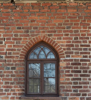 Zdjęcie nr 70: Kościół jest zlokalizowany na wzgórzu, w centrum wsi. Murowany z cegły, w wątku polskim, z zendrówką. Kościół jest orientowany, założony na planie prostokąta, jednonawowy, trójprzęsłowy, z dobudowanymi kruchtami od zachodu i południa. Prezbiterium oddzielone od nawy łukiem tęczowym, dwuprzęsłowe na planie prostokąta, zamknięte prostą ścianą, z dwukondygnacyjną przybudówką zakończoną trójbocznie. Nawa została przykryta sklepieniem sieciowym. Ściana południowa nawy przepruta trzema prostokątnymi oknami, zamkniętymi łukiem ostrym. Okna w nawie i prezbiterium dwudzielne, z sześcioma mniejszymi kwaterami. Przybudówka przy prezbiterium na parterze mieści zakrystię, a na piętrze składzik. Kruchta południowa sklepiona kolebką. Z kruchty do nawy prowadzi ostrołukowy, kamienny portal o dwóch archiwoltach. Kruchta zachodnia, obecnie kaplica św. Franciszka, sklepiona spłaszczoną, ukrytą kopułą na pendentywach. Ściana zachodnia kruchty przepruta dwoma ostrołukowymi oknami i ponad nimi okrągłym oknem. Od południa ostrołukowe wejście. Kościół o zróżnicowanej wysokości nawy i prezbiterium. Ściany opięte szkarpami. Na jednej trzeciej wysokości ścian oraz w zwieńczeniu nawy i prezbiterium profilowany gzyms. Od zachodu wklęsło-wypukły szczyt. Nawa, prezbiterium i dwie kruchty przykryte dachem dwuspadowym. Nad drugim przęsłem prezbiterium wieżyczka na sygnaturkę na planie ośmioboku, z profilowanym gzymsem i latarnią, zwieńczoną hełmem z kulą i krzyżem. Wejście do kościoła od południa i zachodu. Okna nawy i prezbiterium z kamiennym obramieniem. Nad wejściem do kruchty południowej formowany w cegle ostry łuk. Analogiczny łuk nad oknami w ścianie zachodniej i nad blendą w ścianie północnej. W przybudówce do prezbiterium dwie kondygnacje okien zamkniętych łukiem ostrym. W ścianie frontowej prostokątne wejście, a nad nim półkoliście zamknięta wnęka z grupą Ukrzyżowania. 


