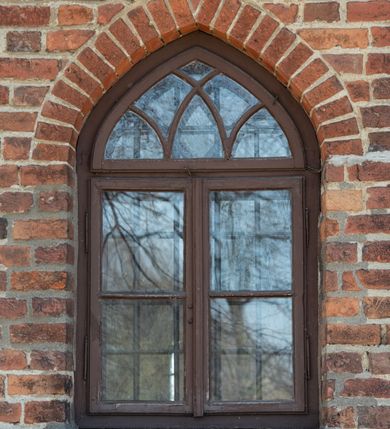 Zdjęcie nr 71: Kościół jest zlokalizowany na wzgórzu, w centrum wsi. Murowany z cegły, w wątku polskim, z zendrówką. Kościół jest orientowany, założony na planie prostokąta, jednonawowy, trójprzęsłowy, z dobudowanymi kruchtami od zachodu i południa. Prezbiterium oddzielone od nawy łukiem tęczowym, dwuprzęsłowe na planie prostokąta, zamknięte prostą ścianą, z dwukondygnacyjną przybudówką zakończoną trójbocznie. Nawa została przykryta sklepieniem sieciowym. Ściana południowa nawy przepruta trzema prostokątnymi oknami, zamkniętymi łukiem ostrym. Okna w nawie i prezbiterium dwudzielne, z sześcioma mniejszymi kwaterami. Przybudówka przy prezbiterium na parterze mieści zakrystię, a na piętrze składzik. Kruchta południowa sklepiona kolebką. Z kruchty do nawy prowadzi ostrołukowy, kamienny portal o dwóch archiwoltach. Kruchta zachodnia, obecnie kaplica św. Franciszka, sklepiona spłaszczoną, ukrytą kopułą na pendentywach. Ściana zachodnia kruchty przepruta dwoma ostrołukowymi oknami i ponad nimi okrągłym oknem. Od południa ostrołukowe wejście. Kościół o zróżnicowanej wysokości nawy i prezbiterium. Ściany opięte szkarpami. Na jednej trzeciej wysokości ścian oraz w zwieńczeniu nawy i prezbiterium profilowany gzyms. Od zachodu wklęsło-wypukły szczyt. Nawa, prezbiterium i dwie kruchty przykryte dachem dwuspadowym. Nad drugim przęsłem prezbiterium wieżyczka na sygnaturkę na planie ośmioboku, z profilowanym gzymsem i latarnią, zwieńczoną hełmem z kulą i krzyżem. Wejście do kościoła od południa i zachodu. Okna nawy i prezbiterium z kamiennym obramieniem. Nad wejściem do kruchty południowej formowany w cegle ostry łuk. Analogiczny łuk nad oknami w ścianie zachodniej i nad blendą w ścianie północnej. W przybudówce do prezbiterium dwie kondygnacje okien zamkniętych łukiem ostrym. W ścianie frontowej prostokątne wejście, a nad nim półkoliście zamknięta wnęka z grupą Ukrzyżowania. 


