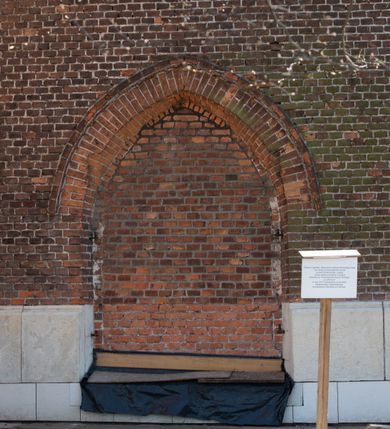 Zdjęcie nr 60: Kościół jest zlokalizowany na wzgórzu, w centrum wsi. Murowany z cegły, w wątku polskim, z zendrówką. Kościół jest orientowany, założony na planie prostokąta, jednonawowy, trójprzęsłowy, z dobudowanymi kruchtami od zachodu i południa. Prezbiterium oddzielone od nawy łukiem tęczowym, dwuprzęsłowe na planie prostokąta, zamknięte prostą ścianą, z dwukondygnacyjną przybudówką zakończoną trójbocznie. Nawa została przykryta sklepieniem sieciowym. Ściana południowa nawy przepruta trzema prostokątnymi oknami, zamkniętymi łukiem ostrym. Okna w nawie i prezbiterium dwudzielne, z sześcioma mniejszymi kwaterami. Przybudówka przy prezbiterium na parterze mieści zakrystię, a na piętrze składzik. Kruchta południowa sklepiona kolebką. Z kruchty do nawy prowadzi ostrołukowy, kamienny portal o dwóch archiwoltach. Kruchta zachodnia, obecnie kaplica św. Franciszka, sklepiona spłaszczoną, ukrytą kopułą na pendentywach. Ściana zachodnia kruchty przepruta dwoma ostrołukowymi oknami i ponad nimi okrągłym oknem. Od południa ostrołukowe wejście. Kościół o zróżnicowanej wysokości nawy i prezbiterium. Ściany opięte szkarpami. Na jednej trzeciej wysokości ścian oraz w zwieńczeniu nawy i prezbiterium profilowany gzyms. Od zachodu wklęsło-wypukły szczyt. Nawa, prezbiterium i dwie kruchty przykryte dachem dwuspadowym. Nad drugim przęsłem prezbiterium wieżyczka na sygnaturkę na planie ośmioboku, z profilowanym gzymsem i latarnią, zwieńczoną hełmem z kulą i krzyżem. Wejście do kościoła od południa i zachodu. Okna nawy i prezbiterium z kamiennym obramieniem. Nad wejściem do kruchty południowej formowany w cegle ostry łuk. Analogiczny łuk nad oknami w ścianie zachodniej i nad blendą w ścianie północnej. W przybudówce do prezbiterium dwie kondygnacje okien zamkniętych łukiem ostrym. W ścianie frontowej prostokątne wejście, a nad nim półkoliście zamknięta wnęka z grupą Ukrzyżowania. 


