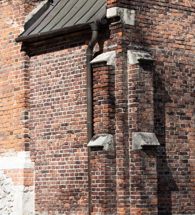 Zdjęcie nr 57: Kościół jest zlokalizowany na wzgórzu, w centrum wsi. Murowany z cegły, w wątku polskim, z zendrówką. Kościół jest orientowany, założony na planie prostokąta, jednonawowy, trójprzęsłowy, z dobudowanymi kruchtami od zachodu i południa. Prezbiterium oddzielone od nawy łukiem tęczowym, dwuprzęsłowe na planie prostokąta, zamknięte prostą ścianą, z dwukondygnacyjną przybudówką zakończoną trójbocznie. Nawa została przykryta sklepieniem sieciowym. Ściana południowa nawy przepruta trzema prostokątnymi oknami, zamkniętymi łukiem ostrym. Okna w nawie i prezbiterium dwudzielne, z sześcioma mniejszymi kwaterami. Przybudówka przy prezbiterium na parterze mieści zakrystię, a na piętrze składzik. Kruchta południowa sklepiona kolebką. Z kruchty do nawy prowadzi ostrołukowy, kamienny portal o dwóch archiwoltach. Kruchta zachodnia, obecnie kaplica św. Franciszka, sklepiona spłaszczoną, ukrytą kopułą na pendentywach. Ściana zachodnia kruchty przepruta dwoma ostrołukowymi oknami i ponad nimi okrągłym oknem. Od południa ostrołukowe wejście. Kościół o zróżnicowanej wysokości nawy i prezbiterium. Ściany opięte szkarpami. Na jednej trzeciej wysokości ścian oraz w zwieńczeniu nawy i prezbiterium profilowany gzyms. Od zachodu wklęsło-wypukły szczyt. Nawa, prezbiterium i dwie kruchty przykryte dachem dwuspadowym. Nad drugim przęsłem prezbiterium wieżyczka na sygnaturkę na planie ośmioboku, z profilowanym gzymsem i latarnią, zwieńczoną hełmem z kulą i krzyżem. Wejście do kościoła od południa i zachodu. Okna nawy i prezbiterium z kamiennym obramieniem. Nad wejściem do kruchty południowej formowany w cegle ostry łuk. Analogiczny łuk nad oknami w ścianie zachodniej i nad blendą w ścianie północnej. W przybudówce do prezbiterium dwie kondygnacje okien zamkniętych łukiem ostrym. W ścianie frontowej prostokątne wejście, a nad nim półkoliście zamknięta wnęka z grupą Ukrzyżowania. 


