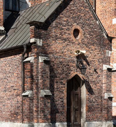 Zdjęcie nr 45: Kościół jest zlokalizowany na wzgórzu, w centrum wsi. Murowany z cegły, w wątku polskim, z zendrówką. Kościół jest orientowany, założony na planie prostokąta, jednonawowy, trójprzęsłowy, z dobudowanymi kruchtami od zachodu i południa. Prezbiterium oddzielone od nawy łukiem tęczowym, dwuprzęsłowe na planie prostokąta, zamknięte prostą ścianą, z dwukondygnacyjną przybudówką zakończoną trójbocznie. Nawa została przykryta sklepieniem sieciowym. Ściana południowa nawy przepruta trzema prostokątnymi oknami, zamkniętymi łukiem ostrym. Okna w nawie i prezbiterium dwudzielne, z sześcioma mniejszymi kwaterami. Przybudówka przy prezbiterium na parterze mieści zakrystię, a na piętrze składzik. Kruchta południowa sklepiona kolebką. Z kruchty do nawy prowadzi ostrołukowy, kamienny portal o dwóch archiwoltach. Kruchta zachodnia, obecnie kaplica św. Franciszka, sklepiona spłaszczoną, ukrytą kopułą na pendentywach. Ściana zachodnia kruchty przepruta dwoma ostrołukowymi oknami i ponad nimi okrągłym oknem. Od południa ostrołukowe wejście. Kościół o zróżnicowanej wysokości nawy i prezbiterium. Ściany opięte szkarpami. Na jednej trzeciej wysokości ścian oraz w zwieńczeniu nawy i prezbiterium profilowany gzyms. Od zachodu wklęsło-wypukły szczyt. Nawa, prezbiterium i dwie kruchty przykryte dachem dwuspadowym. Nad drugim przęsłem prezbiterium wieżyczka na sygnaturkę na planie ośmioboku, z profilowanym gzymsem i latarnią, zwieńczoną hełmem z kulą i krzyżem. Wejście do kościoła od południa i zachodu. Okna nawy i prezbiterium z kamiennym obramieniem. Nad wejściem do kruchty południowej formowany w cegle ostry łuk. Analogiczny łuk nad oknami w ścianie zachodniej i nad blendą w ścianie północnej. W przybudówce do prezbiterium dwie kondygnacje okien zamkniętych łukiem ostrym. W ścianie frontowej prostokątne wejście, a nad nim półkoliście zamknięta wnęka z grupą Ukrzyżowania. 


