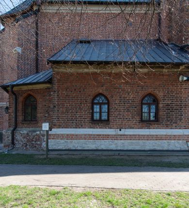 Zdjęcie nr 68: Kościół jest zlokalizowany na wzgórzu, w centrum wsi. Murowany z cegły, w wątku polskim, z zendrówką. Kościół jest orientowany, założony na planie prostokąta, jednonawowy, trójprzęsłowy, z dobudowanymi kruchtami od zachodu i południa. Prezbiterium oddzielone od nawy łukiem tęczowym, dwuprzęsłowe na planie prostokąta, zamknięte prostą ścianą, z dwukondygnacyjną przybudówką zakończoną trójbocznie. Nawa została przykryta sklepieniem sieciowym. Ściana południowa nawy przepruta trzema prostokątnymi oknami, zamkniętymi łukiem ostrym. Okna w nawie i prezbiterium dwudzielne, z sześcioma mniejszymi kwaterami. Przybudówka przy prezbiterium na parterze mieści zakrystię, a na piętrze składzik. Kruchta południowa sklepiona kolebką. Z kruchty do nawy prowadzi ostrołukowy, kamienny portal o dwóch archiwoltach. Kruchta zachodnia, obecnie kaplica św. Franciszka, sklepiona spłaszczoną, ukrytą kopułą na pendentywach. Ściana zachodnia kruchty przepruta dwoma ostrołukowymi oknami i ponad nimi okrągłym oknem. Od południa ostrołukowe wejście. Kościół o zróżnicowanej wysokości nawy i prezbiterium. Ściany opięte szkarpami. Na jednej trzeciej wysokości ścian oraz w zwieńczeniu nawy i prezbiterium profilowany gzyms. Od zachodu wklęsło-wypukły szczyt. Nawa, prezbiterium i dwie kruchty przykryte dachem dwuspadowym. Nad drugim przęsłem prezbiterium wieżyczka na sygnaturkę na planie ośmioboku, z profilowanym gzymsem i latarnią, zwieńczoną hełmem z kulą i krzyżem. Wejście do kościoła od południa i zachodu. Okna nawy i prezbiterium z kamiennym obramieniem. Nad wejściem do kruchty południowej formowany w cegle ostry łuk. Analogiczny łuk nad oknami w ścianie zachodniej i nad blendą w ścianie północnej. W przybudówce do prezbiterium dwie kondygnacje okien zamkniętych łukiem ostrym. W ścianie frontowej prostokątne wejście, a nad nim półkoliście zamknięta wnęka z grupą Ukrzyżowania. 


