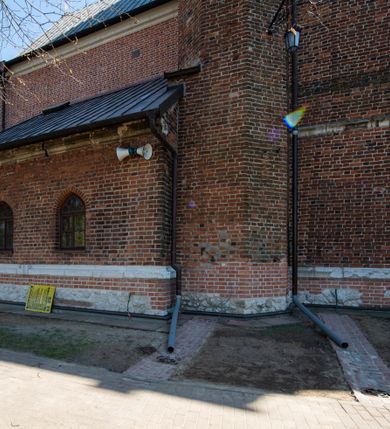 Zdjęcie nr 67: Kościół jest zlokalizowany na wzgórzu, w centrum wsi. Murowany z cegły, w wątku polskim, z zendrówką. Kościół jest orientowany, założony na planie prostokąta, jednonawowy, trójprzęsłowy, z dobudowanymi kruchtami od zachodu i południa. Prezbiterium oddzielone od nawy łukiem tęczowym, dwuprzęsłowe na planie prostokąta, zamknięte prostą ścianą, z dwukondygnacyjną przybudówką zakończoną trójbocznie. Nawa została przykryta sklepieniem sieciowym. Ściana południowa nawy przepruta trzema prostokątnymi oknami, zamkniętymi łukiem ostrym. Okna w nawie i prezbiterium dwudzielne, z sześcioma mniejszymi kwaterami. Przybudówka przy prezbiterium na parterze mieści zakrystię, a na piętrze składzik. Kruchta południowa sklepiona kolebką. Z kruchty do nawy prowadzi ostrołukowy, kamienny portal o dwóch archiwoltach. Kruchta zachodnia, obecnie kaplica św. Franciszka, sklepiona spłaszczoną, ukrytą kopułą na pendentywach. Ściana zachodnia kruchty przepruta dwoma ostrołukowymi oknami i ponad nimi okrągłym oknem. Od południa ostrołukowe wejście. Kościół o zróżnicowanej wysokości nawy i prezbiterium. Ściany opięte szkarpami. Na jednej trzeciej wysokości ścian oraz w zwieńczeniu nawy i prezbiterium profilowany gzyms. Od zachodu wklęsło-wypukły szczyt. Nawa, prezbiterium i dwie kruchty przykryte dachem dwuspadowym. Nad drugim przęsłem prezbiterium wieżyczka na sygnaturkę na planie ośmioboku, z profilowanym gzymsem i latarnią, zwieńczoną hełmem z kulą i krzyżem. Wejście do kościoła od południa i zachodu. Okna nawy i prezbiterium z kamiennym obramieniem. Nad wejściem do kruchty południowej formowany w cegle ostry łuk. Analogiczny łuk nad oknami w ścianie zachodniej i nad blendą w ścianie północnej. W przybudówce do prezbiterium dwie kondygnacje okien zamkniętych łukiem ostrym. W ścianie frontowej prostokątne wejście, a nad nim półkoliście zamknięta wnęka z grupą Ukrzyżowania. 


