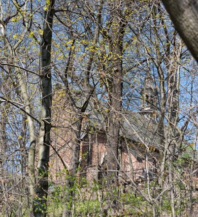 Zdjęcie nr 84: Kościół jest zlokalizowany na wzgórzu, w centrum wsi. Murowany z cegły, w wątku polskim, z zendrówką. Kościół jest orientowany, założony na planie prostokąta, jednonawowy, trójprzęsłowy, z dobudowanymi kruchtami od zachodu i południa. Prezbiterium oddzielone od nawy łukiem tęczowym, dwuprzęsłowe na planie prostokąta, zamknięte prostą ścianą, z dwukondygnacyjną przybudówką zakończoną trójbocznie. Nawa została przykryta sklepieniem sieciowym. Ściana południowa nawy przepruta trzema prostokątnymi oknami, zamkniętymi łukiem ostrym. Okna w nawie i prezbiterium dwudzielne, z sześcioma mniejszymi kwaterami. Przybudówka przy prezbiterium na parterze mieści zakrystię, a na piętrze składzik. Kruchta południowa sklepiona kolebką. Z kruchty do nawy prowadzi ostrołukowy, kamienny portal o dwóch archiwoltach. Kruchta zachodnia, obecnie kaplica św. Franciszka, sklepiona spłaszczoną, ukrytą kopułą na pendentywach. Ściana zachodnia kruchty przepruta dwoma ostrołukowymi oknami i ponad nimi okrągłym oknem. Od południa ostrołukowe wejście. Kościół o zróżnicowanej wysokości nawy i prezbiterium. Ściany opięte szkarpami. Na jednej trzeciej wysokości ścian oraz w zwieńczeniu nawy i prezbiterium profilowany gzyms. Od zachodu wklęsło-wypukły szczyt. Nawa, prezbiterium i dwie kruchty przykryte dachem dwuspadowym. Nad drugim przęsłem prezbiterium wieżyczka na sygnaturkę na planie ośmioboku, z profilowanym gzymsem i latarnią, zwieńczoną hełmem z kulą i krzyżem. Wejście do kościoła od południa i zachodu. Okna nawy i prezbiterium z kamiennym obramieniem. Nad wejściem do kruchty południowej formowany w cegle ostry łuk. Analogiczny łuk nad oknami w ścianie zachodniej i nad blendą w ścianie północnej. W przybudówce do prezbiterium dwie kondygnacje okien zamkniętych łukiem ostrym. W ścianie frontowej prostokątne wejście, a nad nim półkoliście zamknięta wnęka z grupą Ukrzyżowania. 


