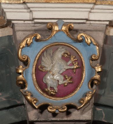 Zdjęcie nr 65: Kaplica pod wezwaniem Najświętszej Marii Panny i Wszystkich Świętych przylega do kościoła od południa, do pierwszego przęsła nawy, z którą komunikuje się za pomocą półkoliście zamkniętej arkady. Zbudowana została na planie kwadratu. Nakryto ją półsferyczną czaszą na pendentywach i zwieńczono latarnią. Wnętrze artykułowano za pomocą ślepej arkady z pilastrami i archiwoltami, ozdobionymi rzeźbioną dekoracją roślinną i kasetonami z rozetami w podłuczu. Ściany kaplicy zamyka wydatne belkowanie z fryzem i łacińską inskrypcją: &quot;DEVS MEVS ET OMNIA / DILEXI DOMINE DECOREM DOMVS / TUAE ET LOCUM HABITATIONIS GLORAE TUAE PSAL(MUS) XXV&quot;. Na czterech pendentywach umieszczono stiukowe kartusze, z czego dwa od strony wschodniej są są puste, a dwa od strony zachodniej wypełniają herby skwadrowane: Gryf, Kotwicz, Kotwicz, Zabawa i Jastrzębiec, Nowina, Gozdawa, Pobóg. Wnętrze doświetlają trzy takie same okulusy umieszczone na każdej ze ścian. Czwarty okulus w ścianie północnej jest zaślepiony. Glify okulusów dekorowane są kasetonami z rozetami. Ściany kaplicy oraz wnętrze kopuły i latarni pokrywa polichromia figuralna. Po arkadą na ścianie wschodniej zawieszono obraz Matki Boskiej z Dzieciątkiem w bogato rzeźbionej roślinno-kwiatowej ramie zwieńczonej godłem z dwiema skrzyżowanymi laskami marszałkowskimi. Pod obrazem znajduje się nagrobek dziecięcy Jana Czuryły (zm. 1560) w formie płaskorzeźbionej, prostokątnej płyty z wyobrażeniem zmarłego. Nad płytą zlokalizowano mniejszą z inskrypcją odnoszącą się do zmarłego. Z kolei wnętrze arkady z herbem Gryf w kluczu na ścianie południowej wypełnia trójosiowy nagrobek Branickich z półokrągłym zwieńczeniem. Natomiast w arkadzie zachodniej wyobrażono scenę Zdjęcia z krzyża w formie malowidła ściennego. Wyposażenie wnętrza dopełniają dwie drewniane ławy kościelne. Ściany zewnętrzne wspierają dwie niskie przypory widoczne w narożach kaplicy. Całość zakończona jest belkowaniem z fryzem zawierającym inskrypcję: &quot;AD LAVDEM DEI OPT(IMO) M(AXIMO) BEATEQUE GENITRICIS MARIAE VIRGINIS ET OMNIUM SANCTORU(M) HONOREM JOHANNES A RVSCZA BRANICZKI VENATOR CRACOVIEN(SIS) ET CAPITANEVS NIEPOLONICEN(SIS) - HANC CAPELLAM EX FVNDAMENTIS EREXIT ANNO D(OMI)NI 1596&quot;. Na ścianie południowej widnieje półokrągła blenda z malowanym przedstawieniem Matki Boskiej Częstochowskiej. Latarnię kaplicy wieńczy głowica z czterema maskami maszkaronów, na której wspiera się złocona kula z krzyżem.