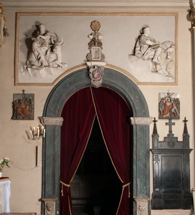 Zdjęcie nr 71: Kaplica pod wezwaniem Najświętszej Marii Panny i Wszystkich Świętych przylega do kościoła od południa, do pierwszego przęsła nawy, z którą komunikuje się za pomocą półkoliście zamkniętej arkady. Zbudowana została na planie kwadratu. Nakryto ją półsferyczną czaszą na pendentywach i zwieńczono latarnią. Wnętrze artykułowano za pomocą ślepej arkady z pilastrami i archiwoltami, ozdobionymi rzeźbioną dekoracją roślinną i kasetonami z rozetami w podłuczu. Ściany kaplicy zamyka wydatne belkowanie z fryzem i łacińską inskrypcją: "DEVS MEVS ET OMNIA / DILEXI DOMINE DECOREM DOMVS / TUAE ET LOCUM HABITATIONIS GLORAE TUAE PSAL(MUS) XXV". Na czterech pendentywach umieszczono stiukowe kartusze, z czego dwa od strony wschodniej są są puste, a dwa od strony zachodniej wypełniają herby skwadrowane: Gryf, Kotwicz, Kotwicz, Zabawa i Jastrzębiec, Nowina, Gozdawa, Pobóg. Wnętrze doświetlają trzy takie same okulusy umieszczone na każdej ze ścian. Czwarty okulus w ścianie północnej jest zaślepiony. Glify okulusów dekorowane są kasetonami z rozetami. Ściany kaplicy oraz wnętrze kopuły i latarni pokrywa polichromia figuralna. Po arkadą na ścianie wschodniej zawieszono obraz Matki Boskiej z Dzieciątkiem w bogato rzeźbionej roślinno-kwiatowej ramie zwieńczonej godłem z dwiema skrzyżowanymi laskami marszałkowskimi. Pod obrazem znajduje się nagrobek dziecięcy Jana Czuryły (zm. 1560) w formie płaskorzeźbionej, prostokątnej płyty z wyobrażeniem zmarłego. Nad płytą zlokalizowano mniejszą z inskrypcją odnoszącą się do zmarłego. Z kolei wnętrze arkady z herbem Gryf w kluczu na ścianie południowej wypełnia trójosiowy nagrobek Branickich z półokrągłym zwieńczeniem. Natomiast w arkadzie zachodniej wyobrażono scenę Zdjęcia z krzyża w formie malowidła ściennego. Wyposażenie wnętrza dopełniają dwie drewniane ławy kościelne. Ściany zewnętrzne wspierają dwie niskie przypory widoczne w narożach kaplicy. Całość zakończona jest belkowaniem z fryzem zawierającym inskrypcję: "AD LAVDEM DEI OPT(IMO) M(AXIMO) BEATEQUE GENITRICIS MARIAE VIRGINIS ET OMNIUM SANCTORU(M) HONOREM JOHANNES A RVSCZA BRANICZKI VENATOR CRACOVIEN(SIS) ET CAPITANEVS NIEPOLONICEN(SIS) - HANC CAPELLAM EX FVNDAMENTIS EREXIT ANNO D(OMI)NI 1596". Na ścianie południowej widnieje półokrągła blenda z malowanym przedstawieniem Matki Boskiej Częstochowskiej. Latarnię kaplicy wieńczy głowica z czterema maskami maszkaronów, na której wspiera się złocona kula z krzyżem.